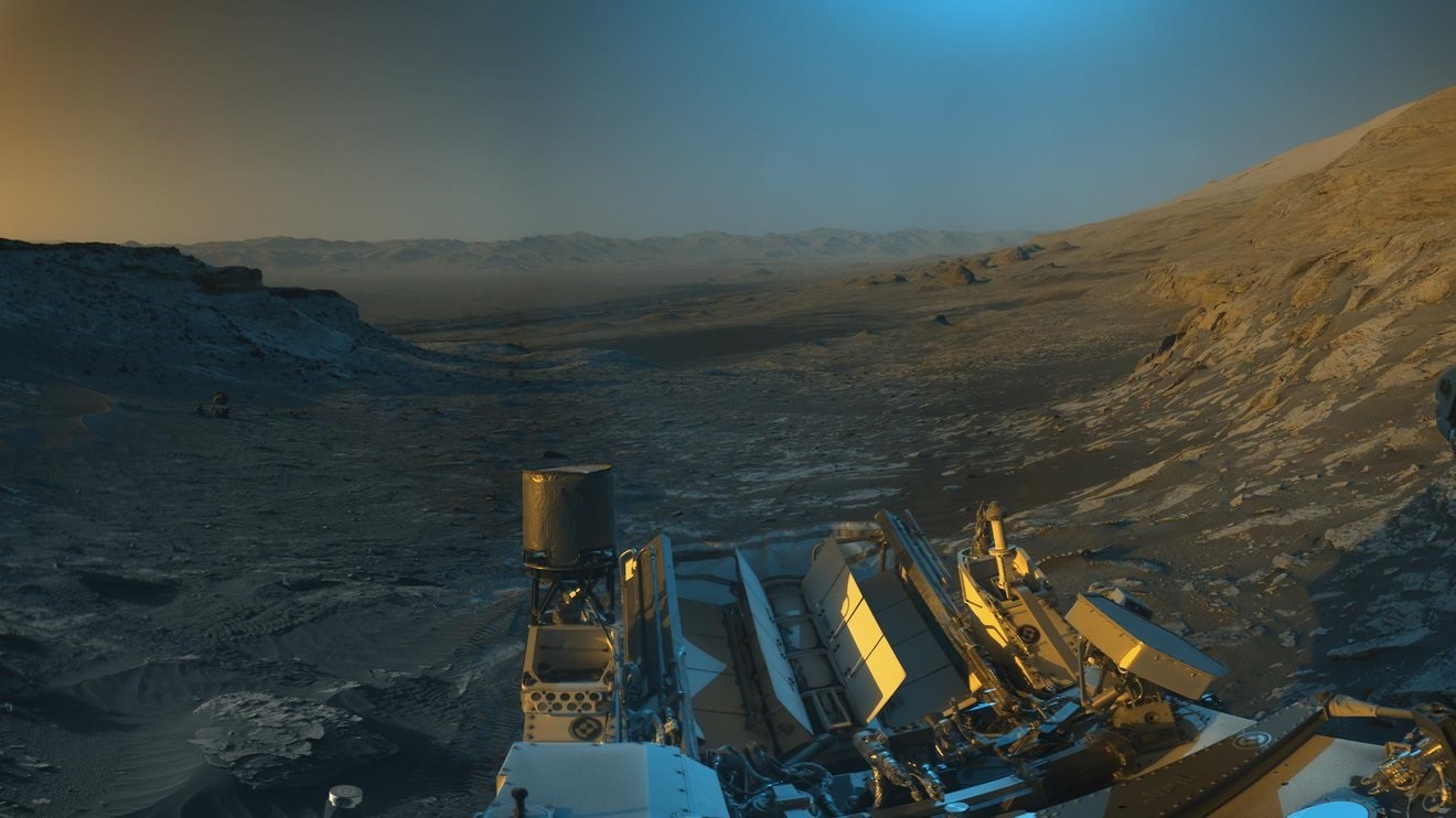 Atónito por el extenso paisaje, el equipo de la misión del rover Curiosity de la NASA en Marte creó una interpretación artística de la vista del vehículo robótico en lo alto de una montaña marciana. (NASA/JPL-CALTECH)
