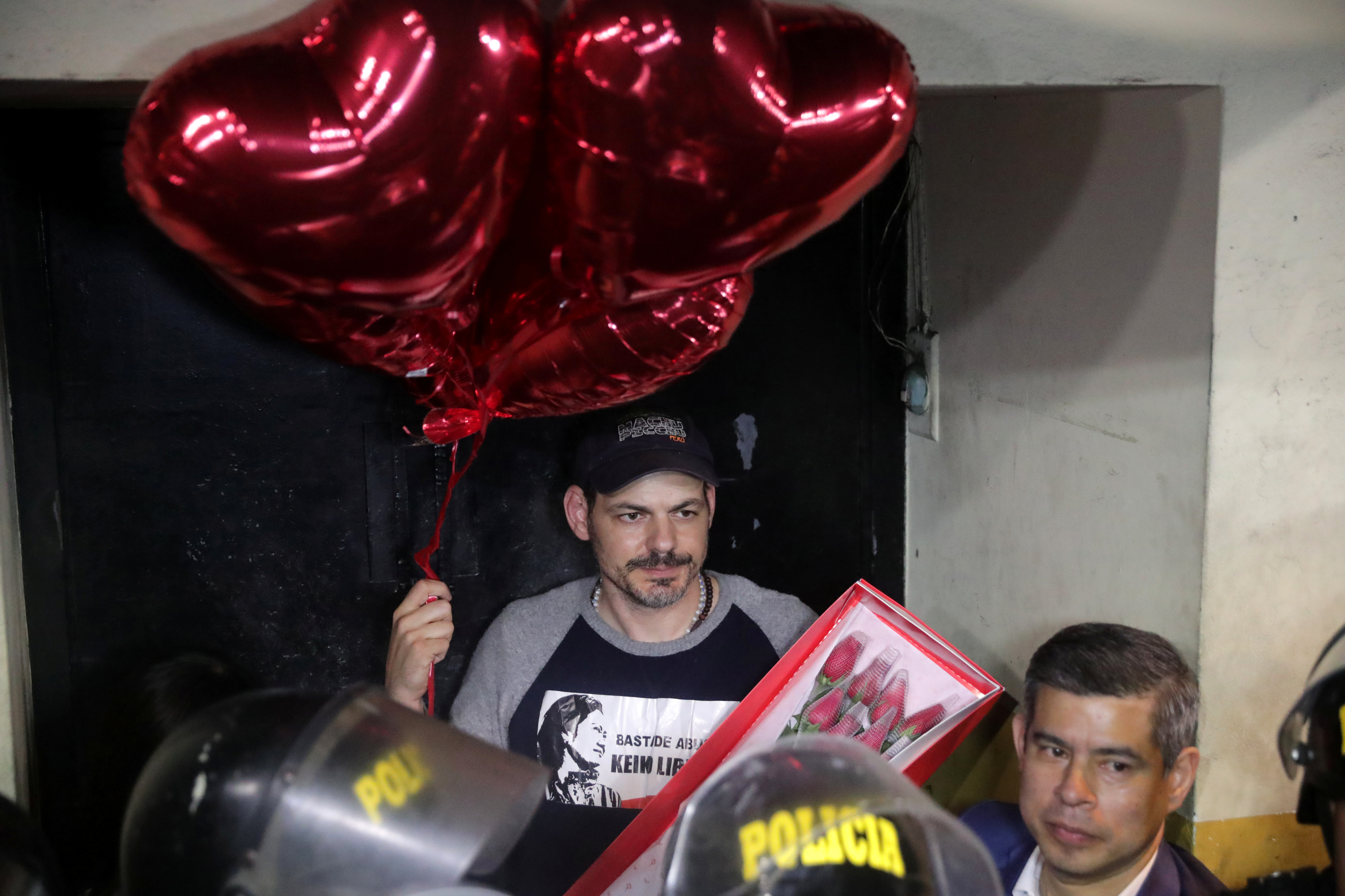 Mark Vito Villanella espera la salida del penal de Keiko Fujimori con un ramo de flores y globos en forma de corazones. REUTERS/Guadalupe Pardo