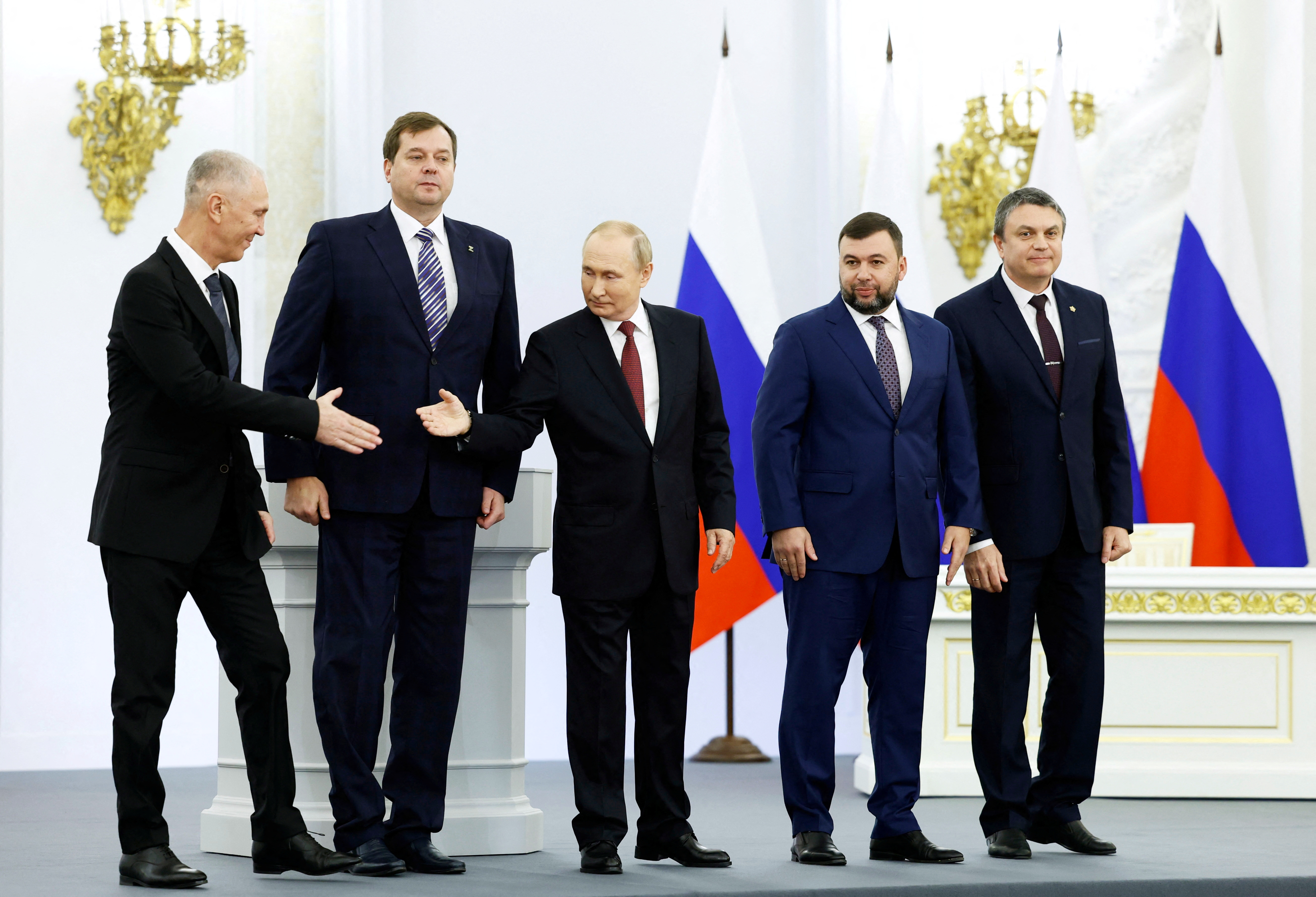 Vladimir Saldo, el gobernador de la ocupación rusa en Kherson le da la mano a Vladimir Putin en la ceremonia por la anexión de los territorios ucranianos realizada en el Kremlin. Sputnik/Dmitry Astakhov/Pool via REUTERS.