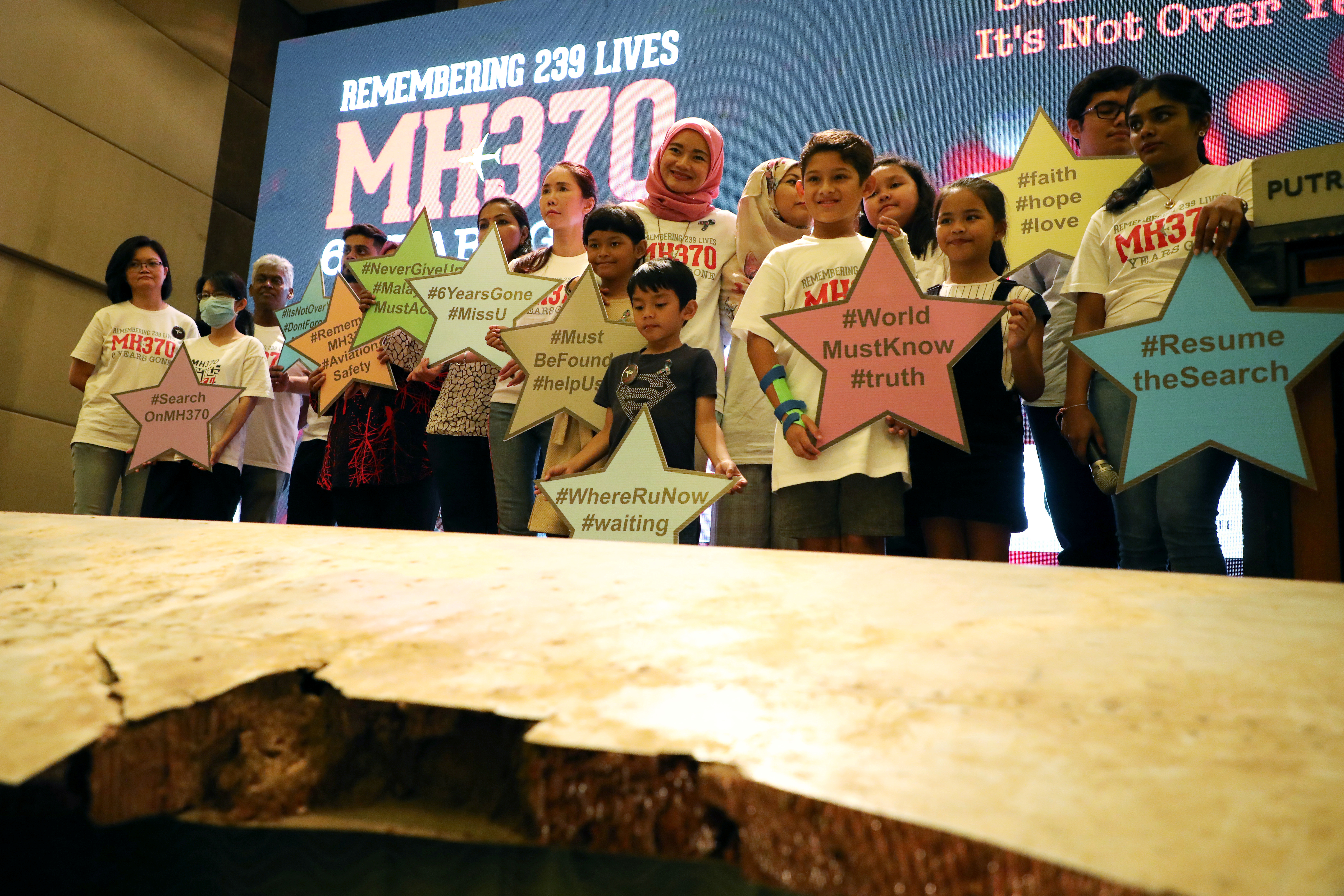 Los familiares de las víctimas frente a los escombros del vuelo MH370 de Malaysia Airlines desaparecido (REUTERS/Lim Huey Teng)