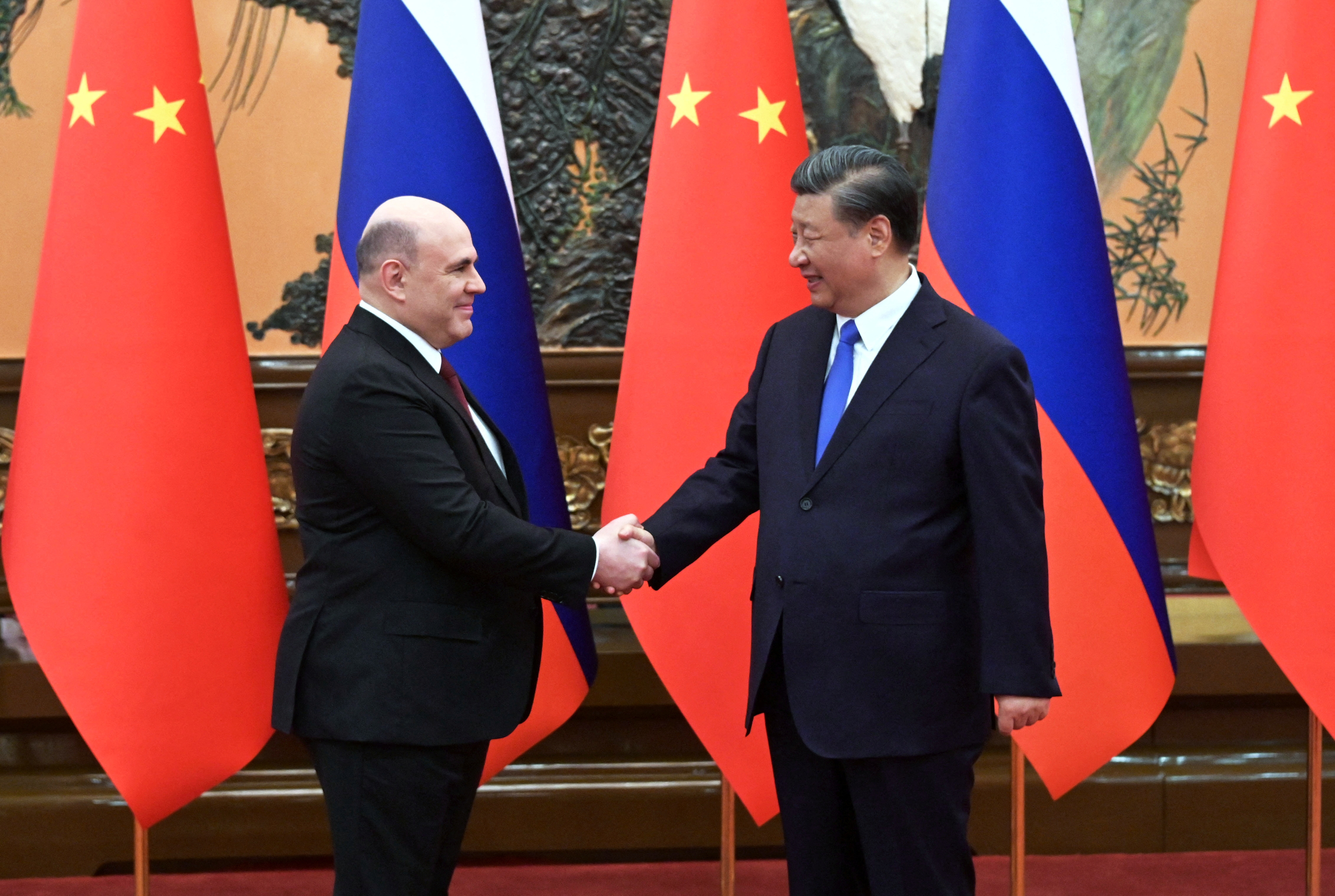 Russian Prime Minister Mikhal Mishustin and Chinese President Xi Jinping shake hands during a meeting at the Great Hall of the People in Beijing[Sputnik/Alexander Astafyev/REUTERS]