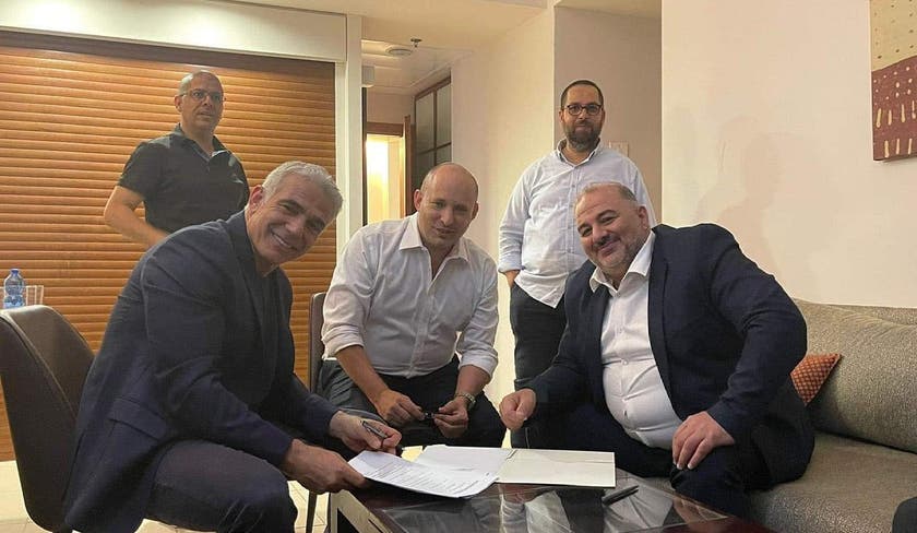 La foto difundida por las redes sociales que muestra el momento de la firma del acuerdo de gobierno entre Yair Lapid (izq.), Naftali Bennet (centro) y Manssour Abbas (derecha).