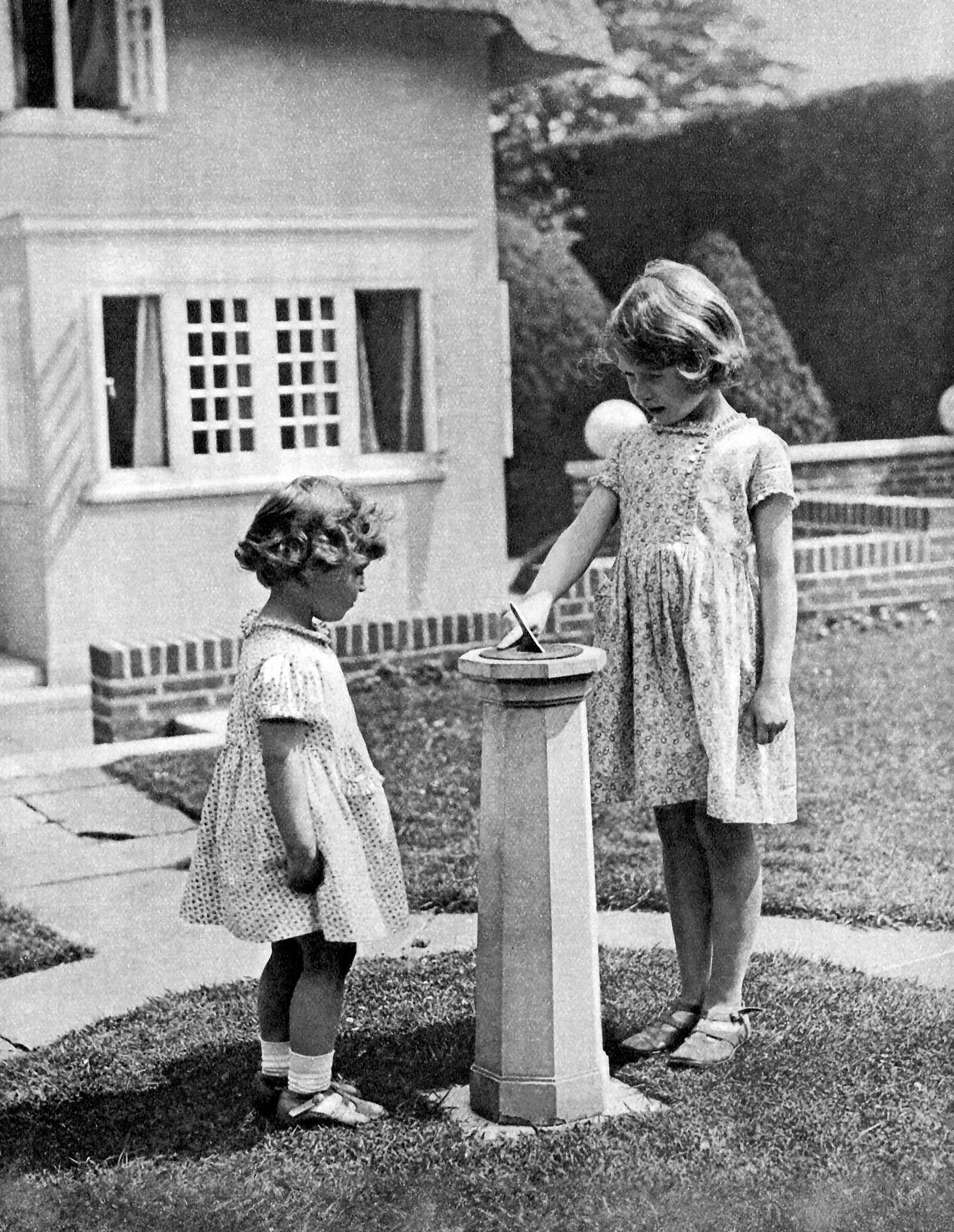 Princess Elizabeth (to become Queen Elizabeth II) and Princess Margaret as children in the 'grounds' of the model house - Y Bwthyn Bach - presented to them on Elizabeth's 6th birthday by the people of Wales, 1933 (Photo by Culture Club/Getty Images)