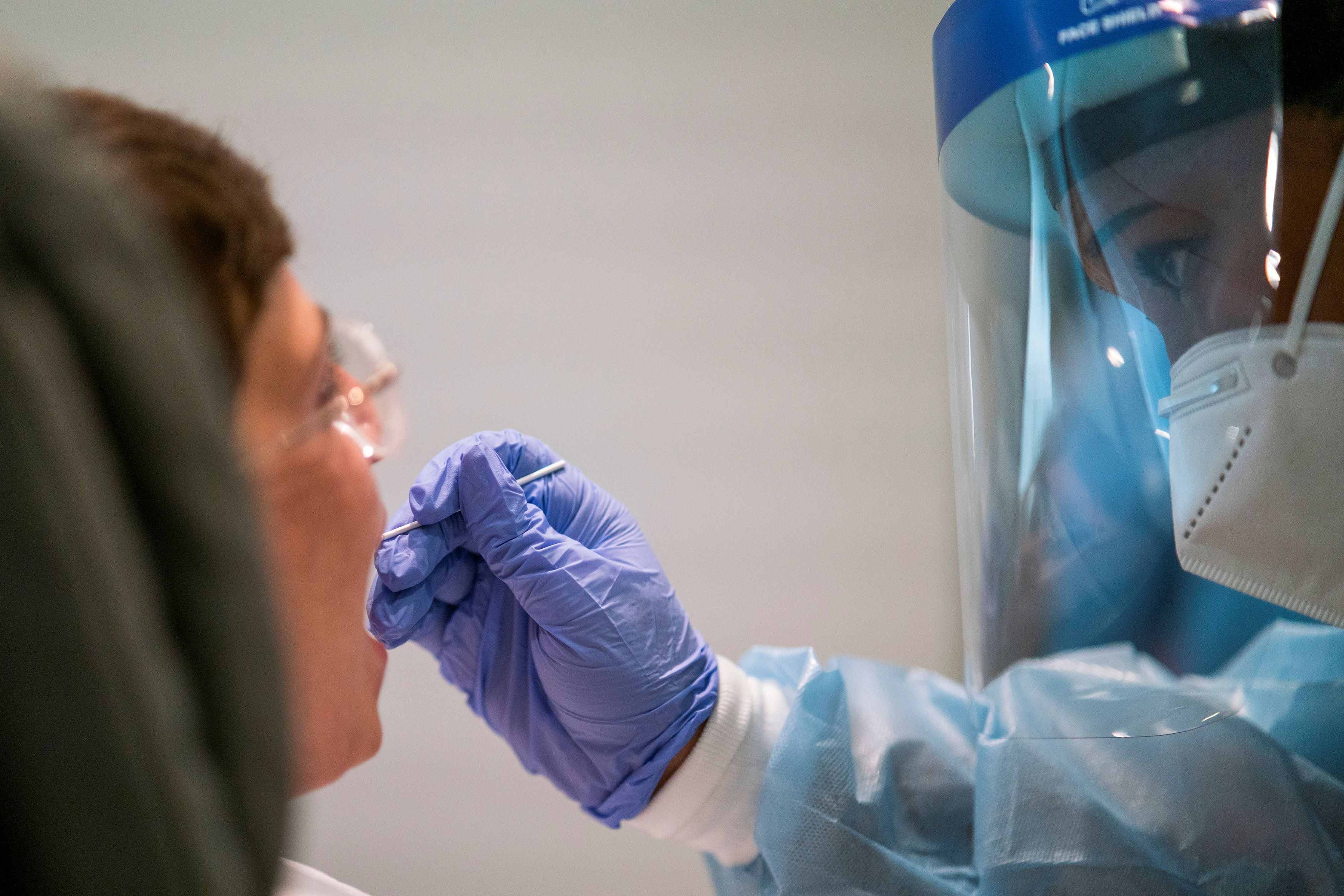Un trabajador sanitario realiza una prueba de la enfermedad por coronavirus (COVID-19) a un viajero aéreo antes de un vuelo de El Al a Israel en el Aeropuerto Internacional JFK de Nueva York, Estados Unidos (REUTERS/Eduardo Muñoz/Archivo)