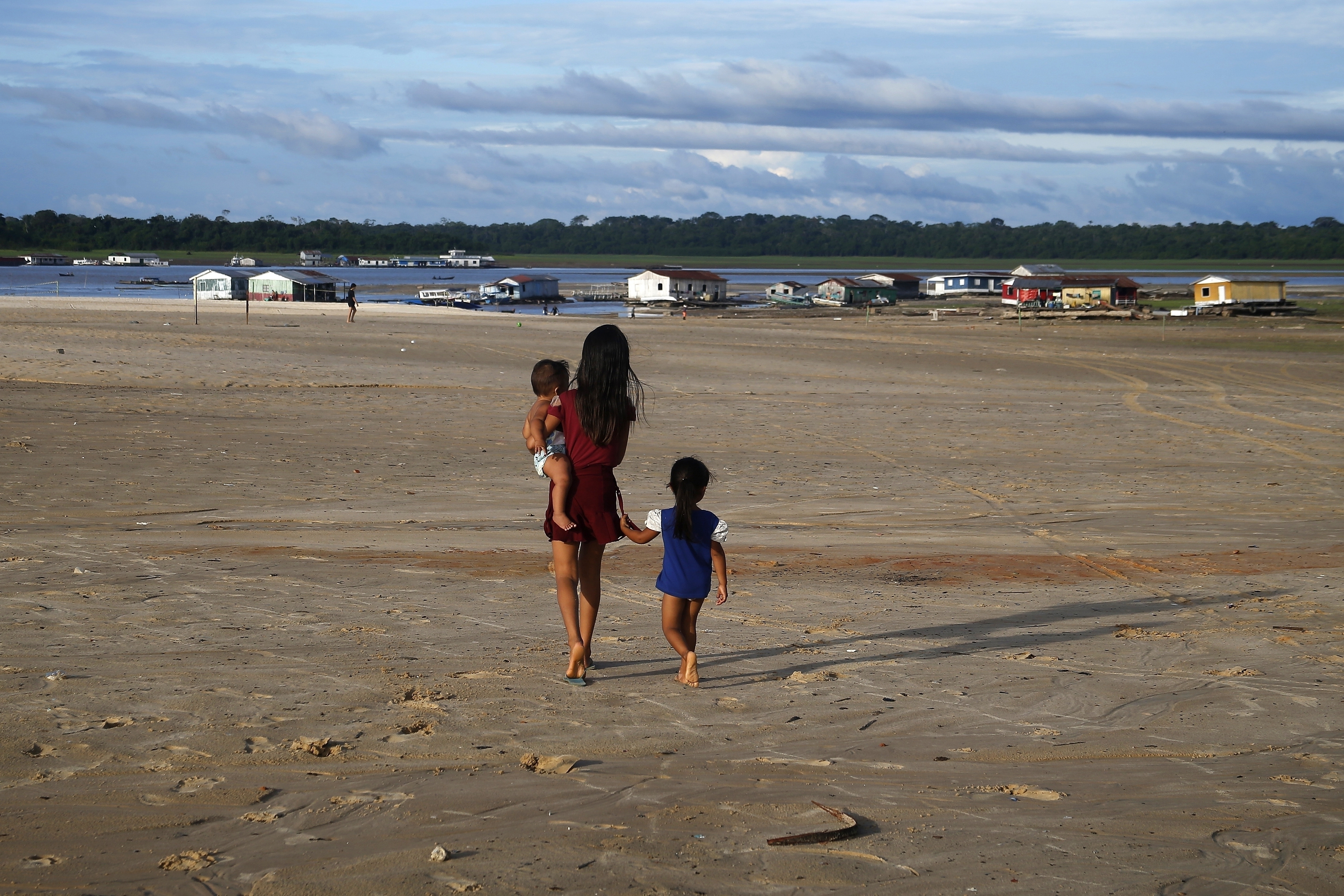 Archivo - Unos niños caminan en una zona afectada por la sequía cerca del río Solimoes, en Tefe, Brasil, el 19 de octubre de 2022. (AP Foto/Edmar Barros, Archivo)
