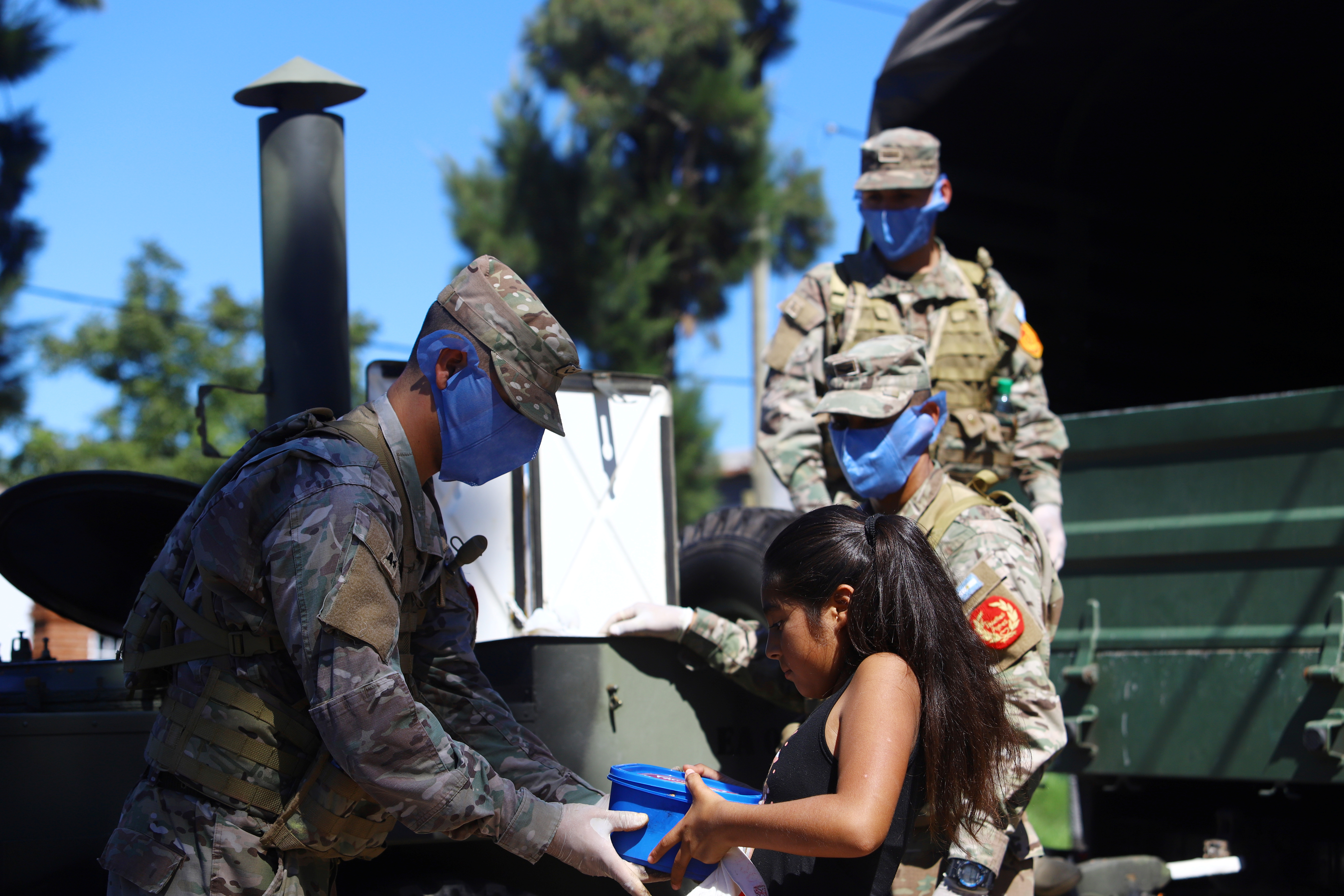 Military staff wearing protective masks delivers a ration of food aid, organized by the municipality for a low-income neighborhood, during the mandatory quarantine for coronavirus disease (COVID-19), in Quilmes, on the outskirts of Buenos Aires, Argentina March 23, 2020