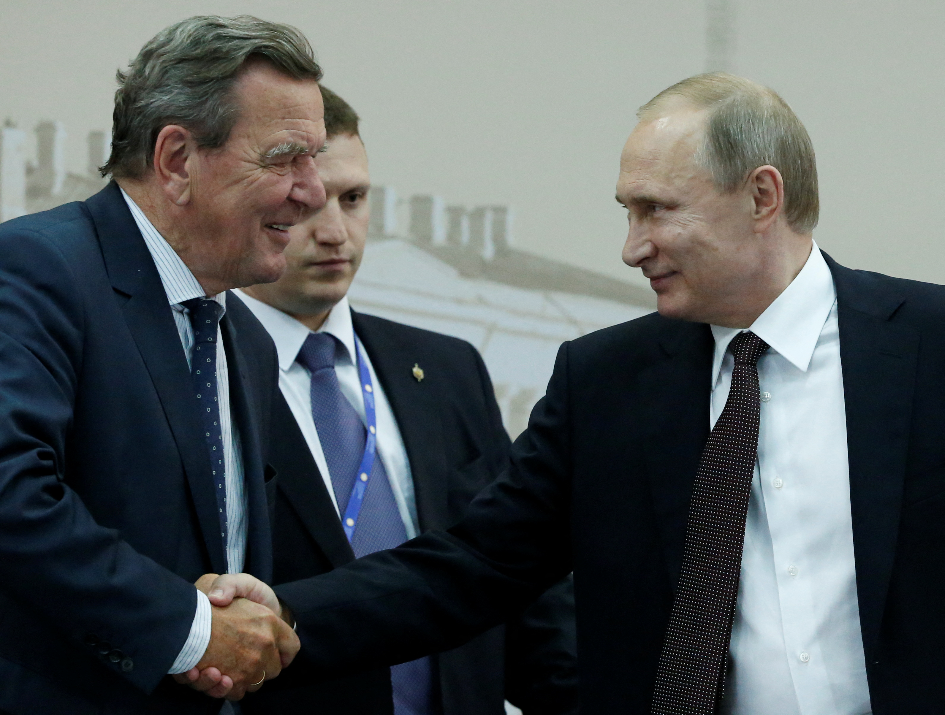 FILE PHOTO: Russian President Vladimir Putin shakes hands with former German Chancellor Gerhard Schroeder during a meeting with heads of foreign companies and business associations as part of the St. Petersburg International Economic Forum 2016 (SPIEF 2016) in St. Petersburg, Russia, June 17, 2016.  REUTERS/Grigory Dukor/File Photo