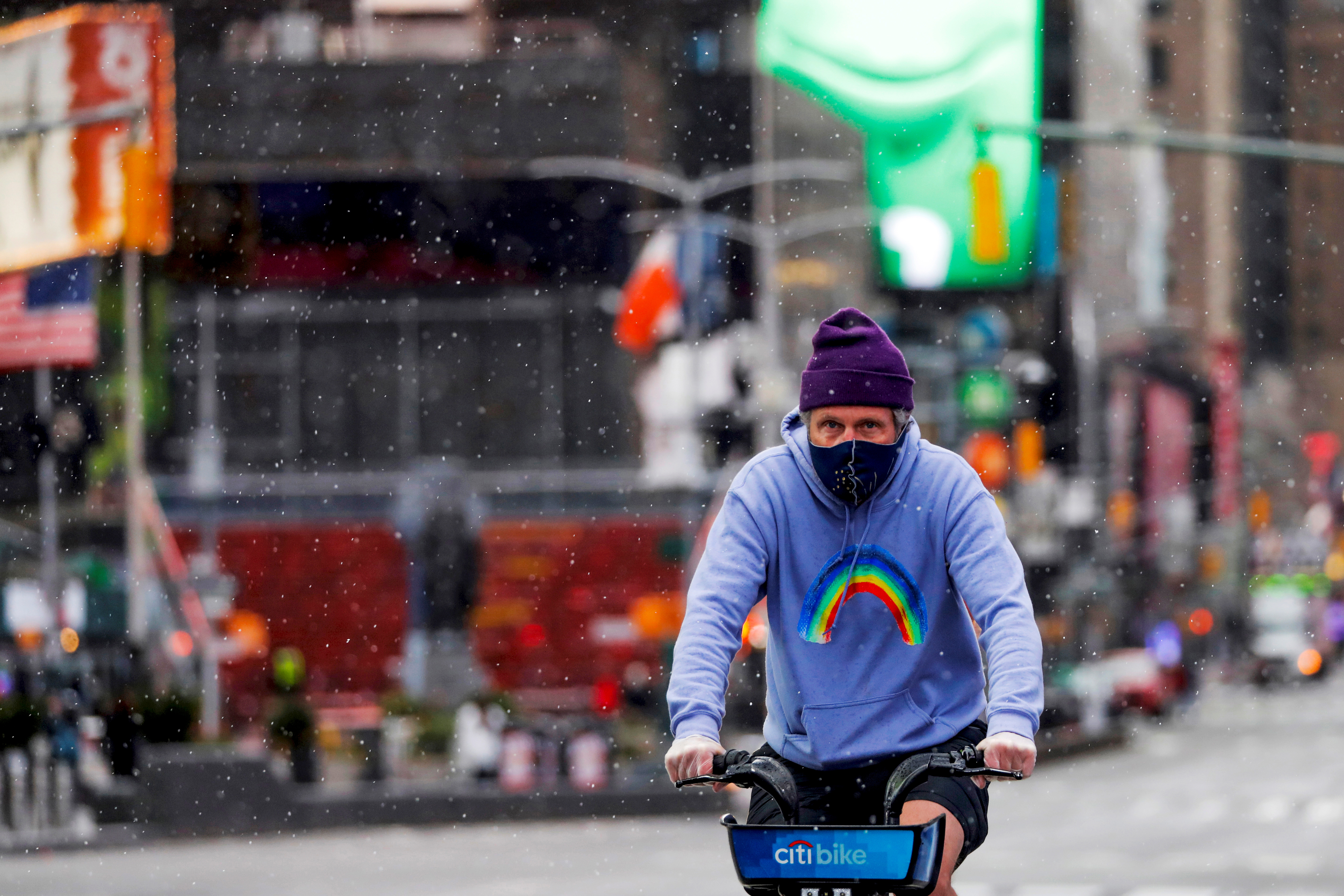 Un hombre recorre Times Square en bicicleta durante una ráfaga de nieve cuando un vórtice polar trajo las frías temperaturas a la región en el distrito de Manhattan de la ciudad de Nueva York, EE.UU., el 9 de mayo de 2020 (Reuters)
