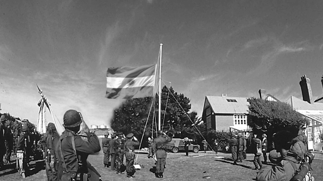 Izamiento de la bandera argentina el 2 de abril. Esta imagen es una de las primeras de las muchas de archivo que aparecen en la película. 