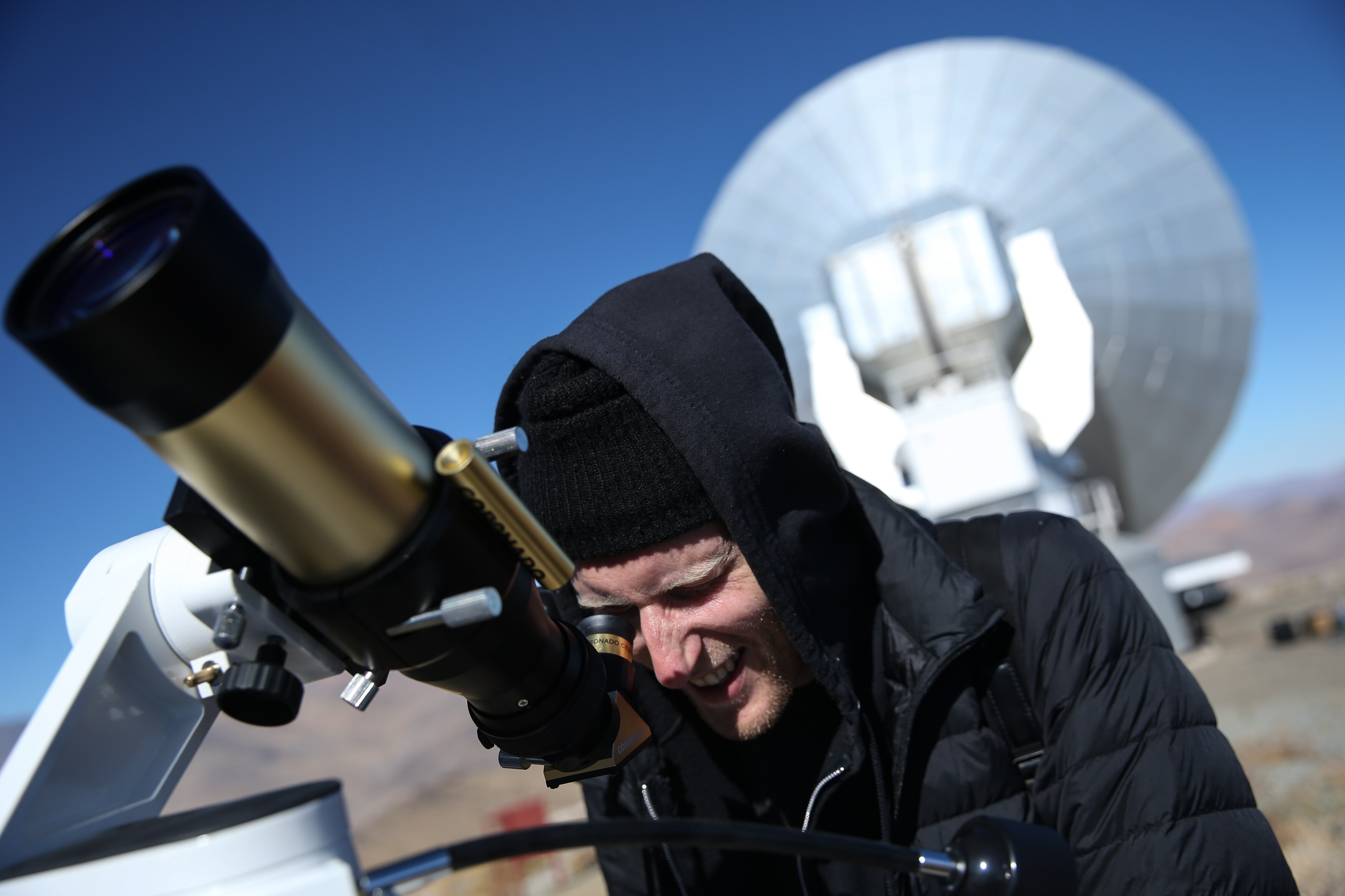 Un hombre observa el sol a través de un telescopio con lentes especiales, horas antes de que comience un eclipse solar en Argentina (EFE/Alberto Valdés) 