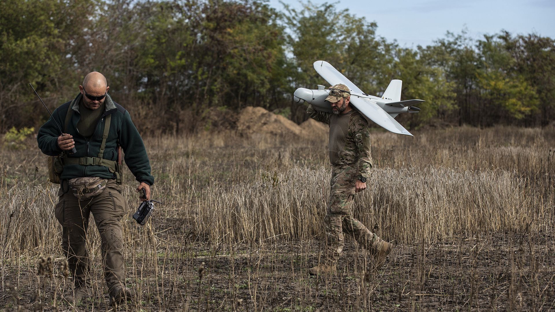 Oleksiy, miembro de la unidad Falcon de las Fuerzas de Defensa Territorial de Kryvyi Rih, observa el terreno para detectar minas de fabricación rusa mientras Viter lleva un dron Leleka-100 de regreso a la base después de una misión