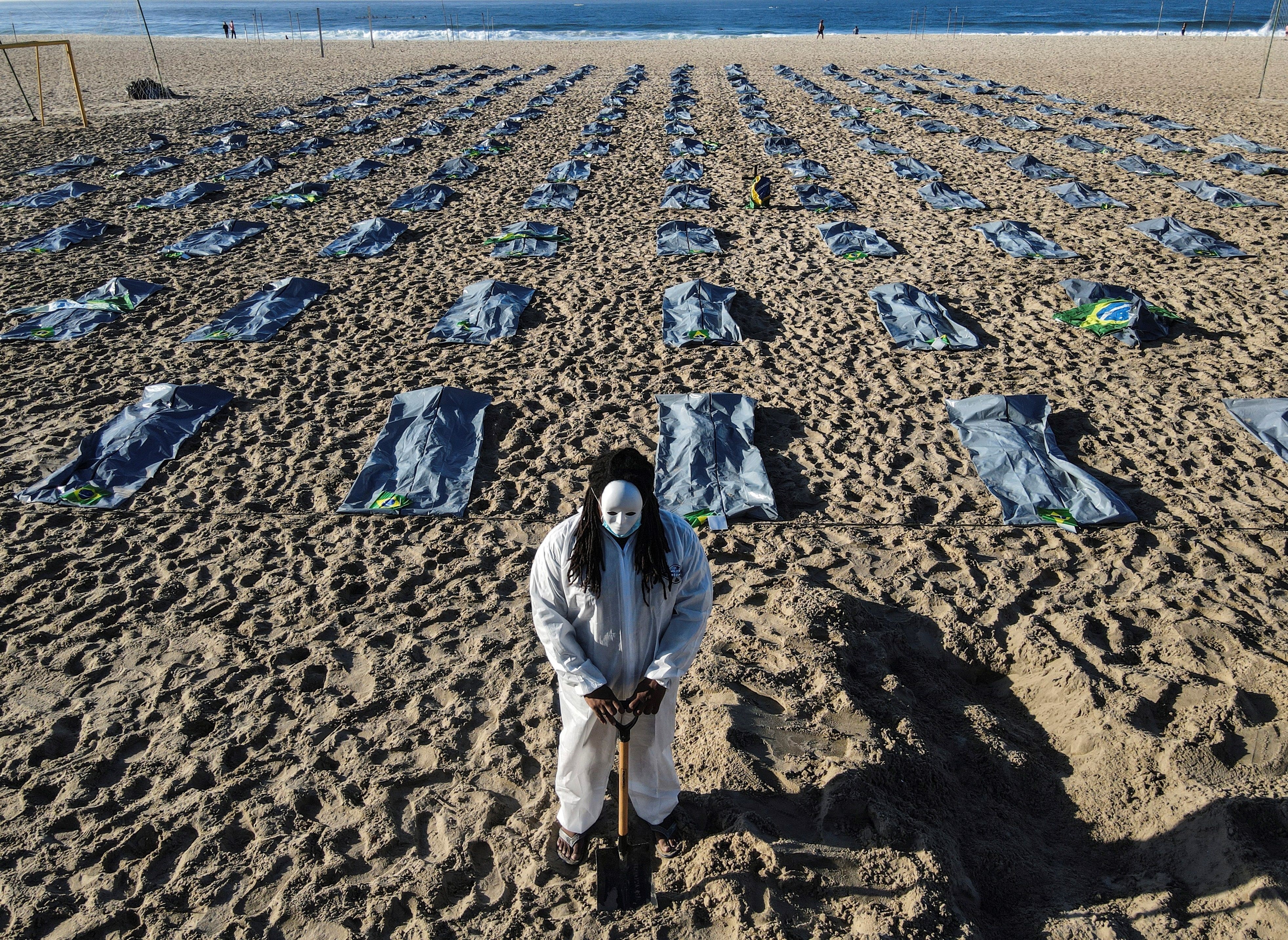 Foto tomada con un dron que muestra elementos que simulan cerca de 400 bolsas mortuorias durante el acto de la ONG Río de Paz en memoria de los más de 400.000 brasileños muertos por el Covid-19, este viernes en las arenas de la playa de Copacabana, en la zona sur de Río de Janeiro, Brasil. EFE/Antonio Lacerda
