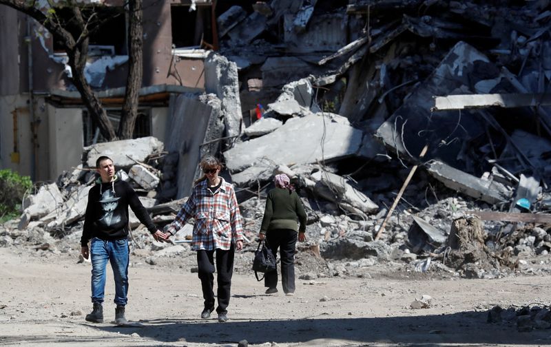 FOTO DE ARCHIVO: Residentes locales junto a un edificio destruido durante el conflicto entre Ucrania y Rusia en la ciudad portuaria del sur de Mariupol (REUTERS/Alexander Ermochenko)