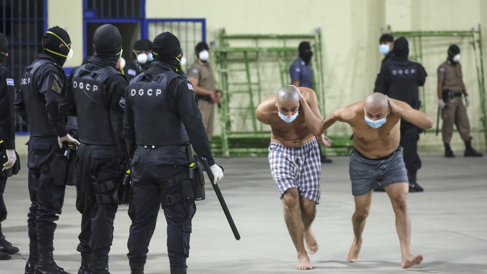 Dos presos son trasladados dentro de un penal en San Salvador, El Salvador (Presidencia de El Salvador vía AP)