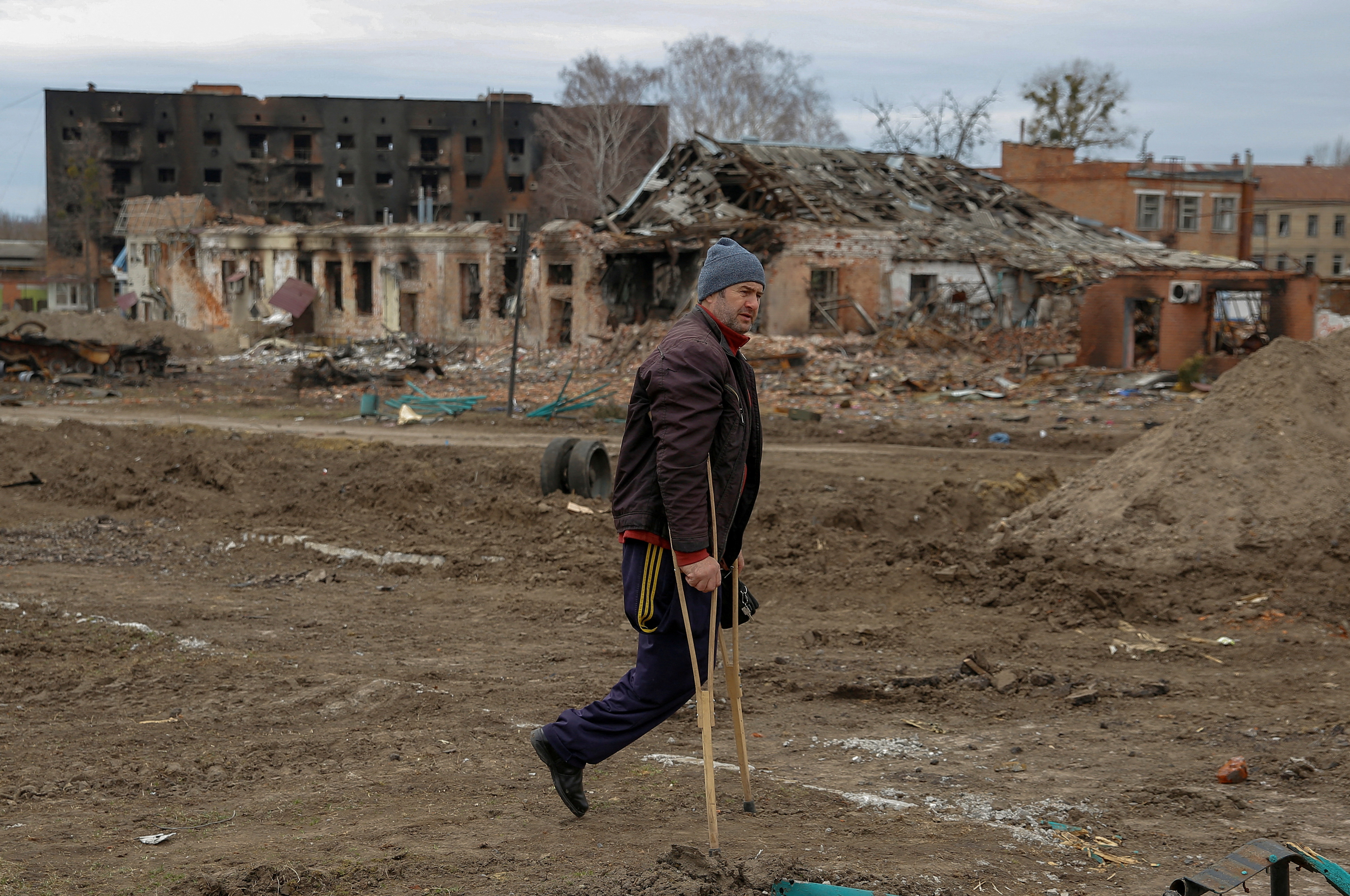 A local resident walks along a square damaged by shelling, as Russia’s attack on Ukraine continues, in the town of Trostianets, in Sumy region, Ukraine March 28, 2022. Picture taken March 28, 2022. REUTERS/Oleg Pereverzev