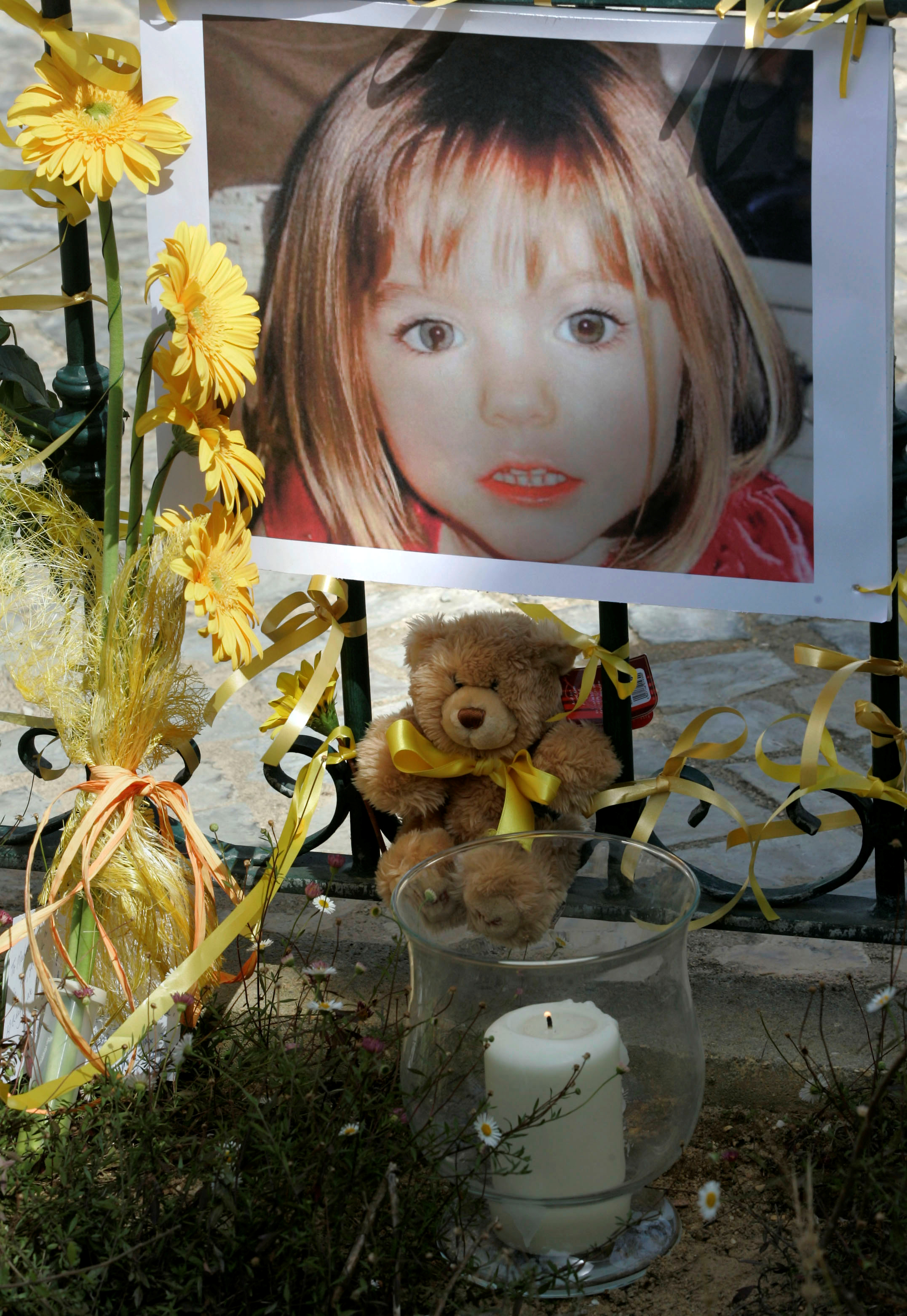El póster de la niña británica de tres años desaparecida Madeleine McCann está rodeada de flores y arcos de esperanza en el balneario portugués de Lagos el 12 de mayo de 2007. REUTERS/Hugo Correia/File Photo