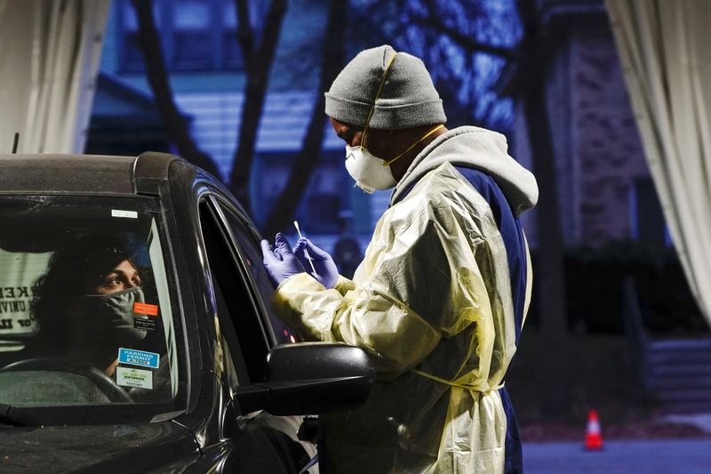 Un agente sanitario se dispone a tomar una muestra de una paciente en un puesto móvil de pruebas de COVID-19 en Milwaukee, en el estado de Wisconsin (REUTERS/Bing Guan)