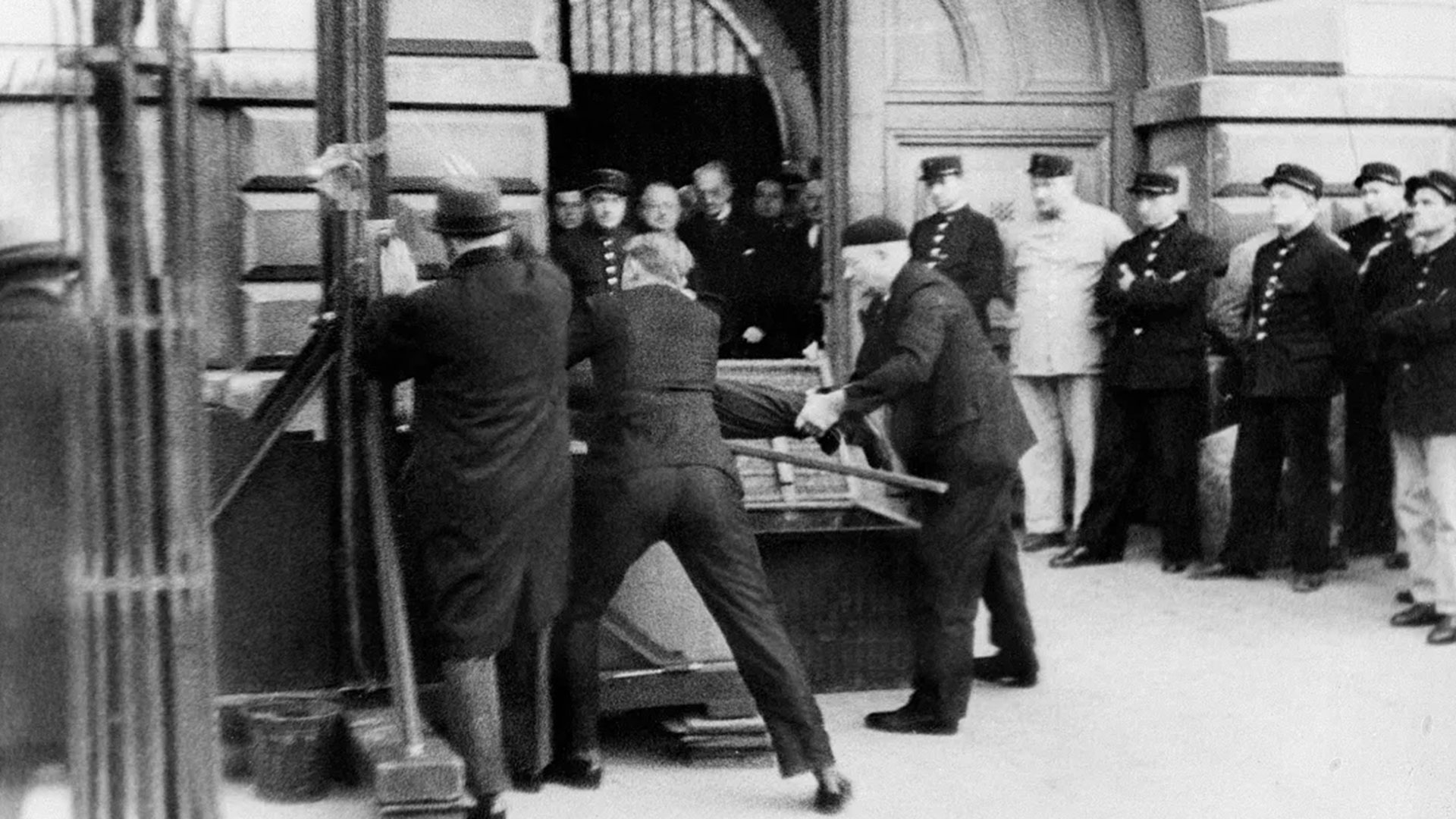 Asistentes del "verdugo de París" sitúan a Eugen Weidmann, condenado a muerte por 5 asesinatos, en la guillotina antes de su ejecución pública, el 17 de junio de 1939 en Versalles. El macabro espectáculo que se dio toda la noche en Versalles, al pie de la guillotina, llevó a la prohibición de este tipo de ejecuciones. La pena de muerte fue abolida en Francia en 1981 (STF / AFP)