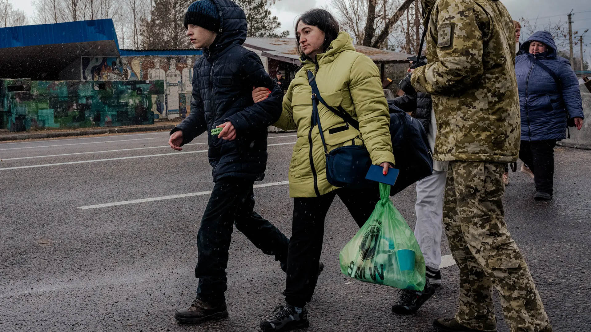 Olha Mazur with her son, Oleksandr Chugunov, after crossing the border from Belarus into Ukraine, in Volyn Oblast, Ukraine, on March 21, 2023. (Daniel Berehulak/The New York Times)