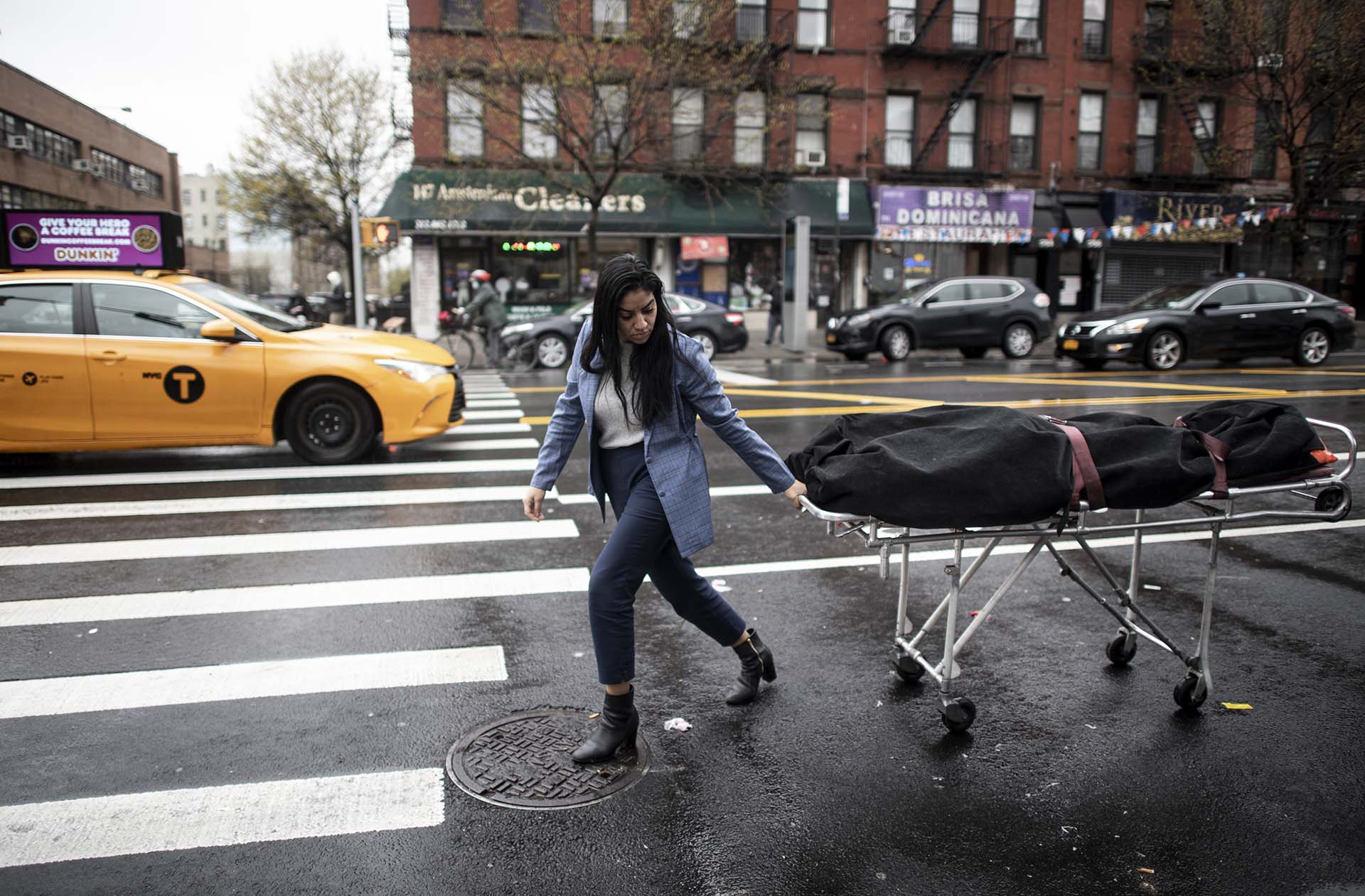 Alisha Narvaez, directora de un servicio de cremación en Nueva York,  traslada el cuerpo de una víctima de covid-19 por una calle de Harlem. (24 de abril)
