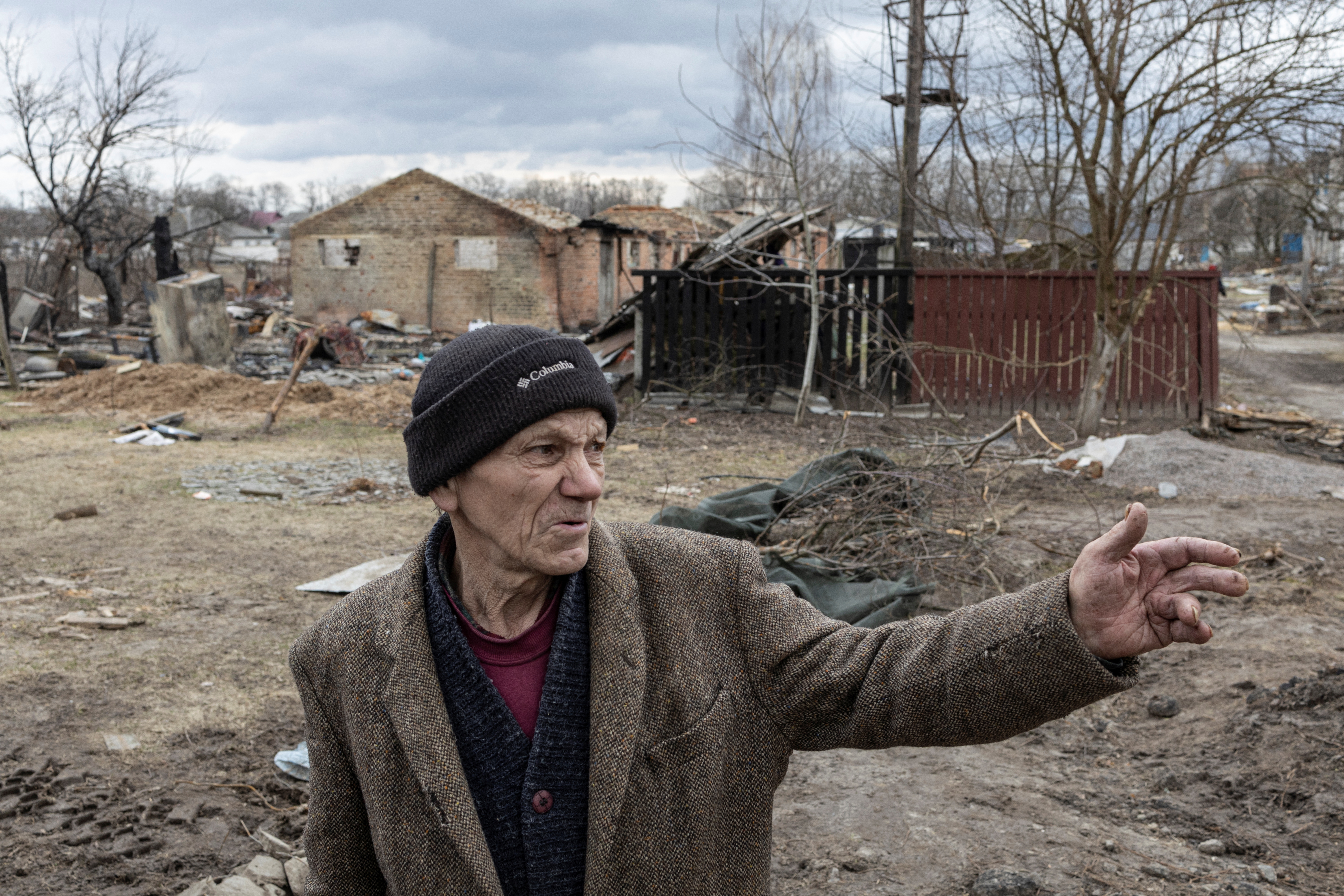 Petro Hlystun, de 71 años, hace gestos frente a las casas destruidas de su pueblo, Yahidne REUTERS/Marko Djurica 
