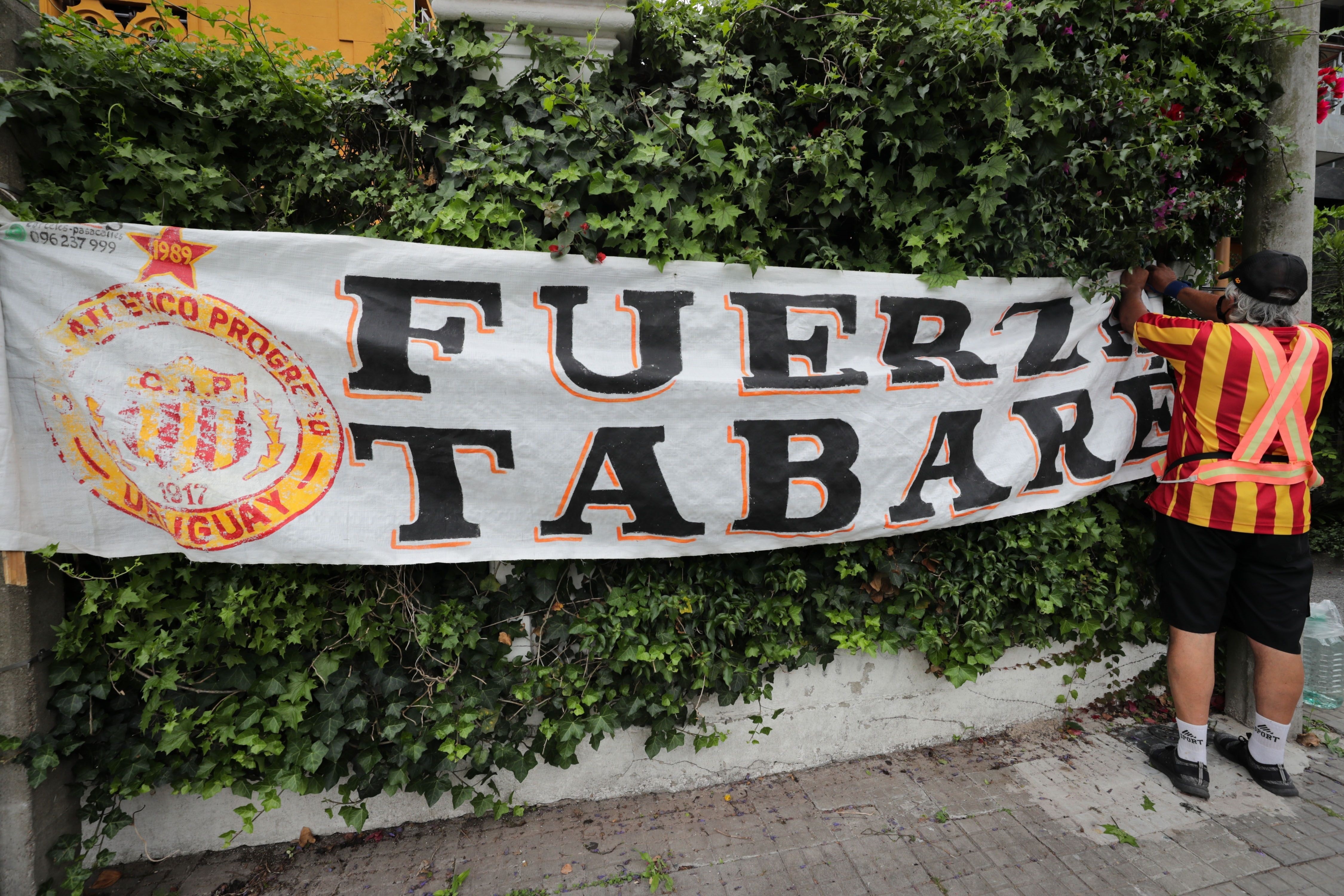 Un hincha del Club Progreso cuelga una pancarta de apoyo al ex presidente de Uruguay, días antes de su fallecimiento
