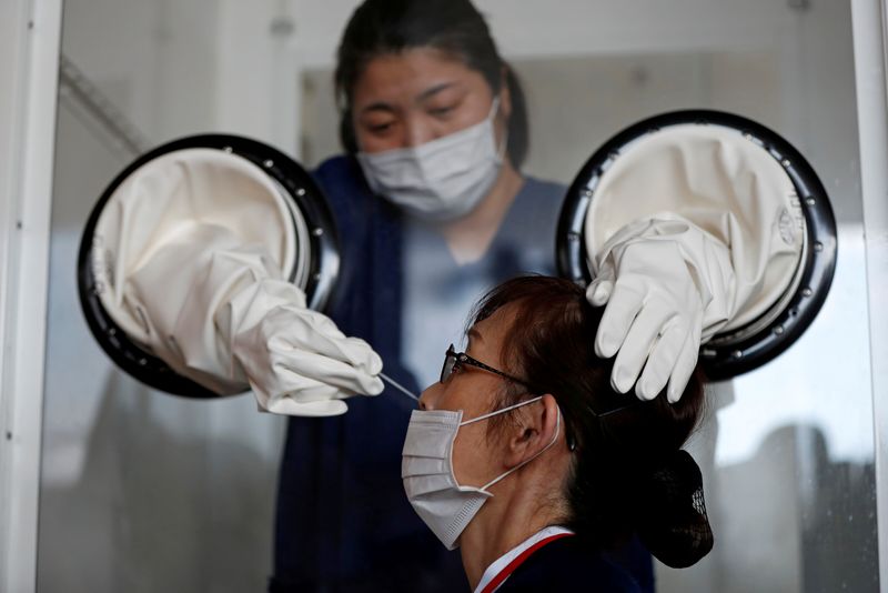 Una trabajadora sanitaria realiza una prueba de test PCR para detectar la enfermedad COVID-19 en una instalación en Yokosuka, al sur de Tokio, Japón, el 23 de abril de 2020. REUTERS/Issei Kato