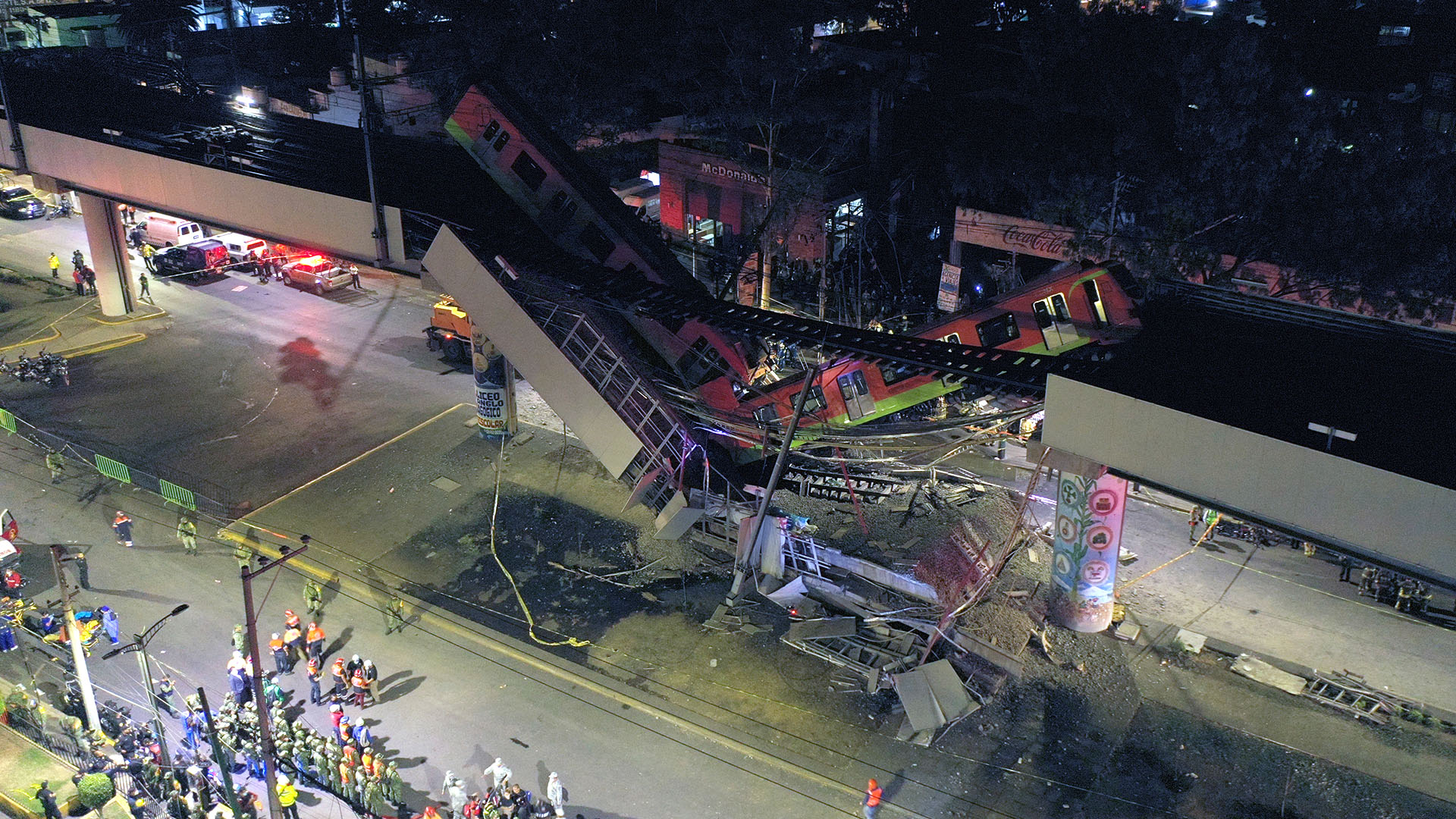 An aerial view shows rescue workers at the site of a metro train accident after an overpass for a metro partially collapsed in Mexico City on May 3, 2021. - At least 15 people were killed and dozens injured when an elevated metro line collapsed in the Mexican capital on May 3 as a train was passing, authorities said. (Photo by PEDRO PARDO / AFP)
