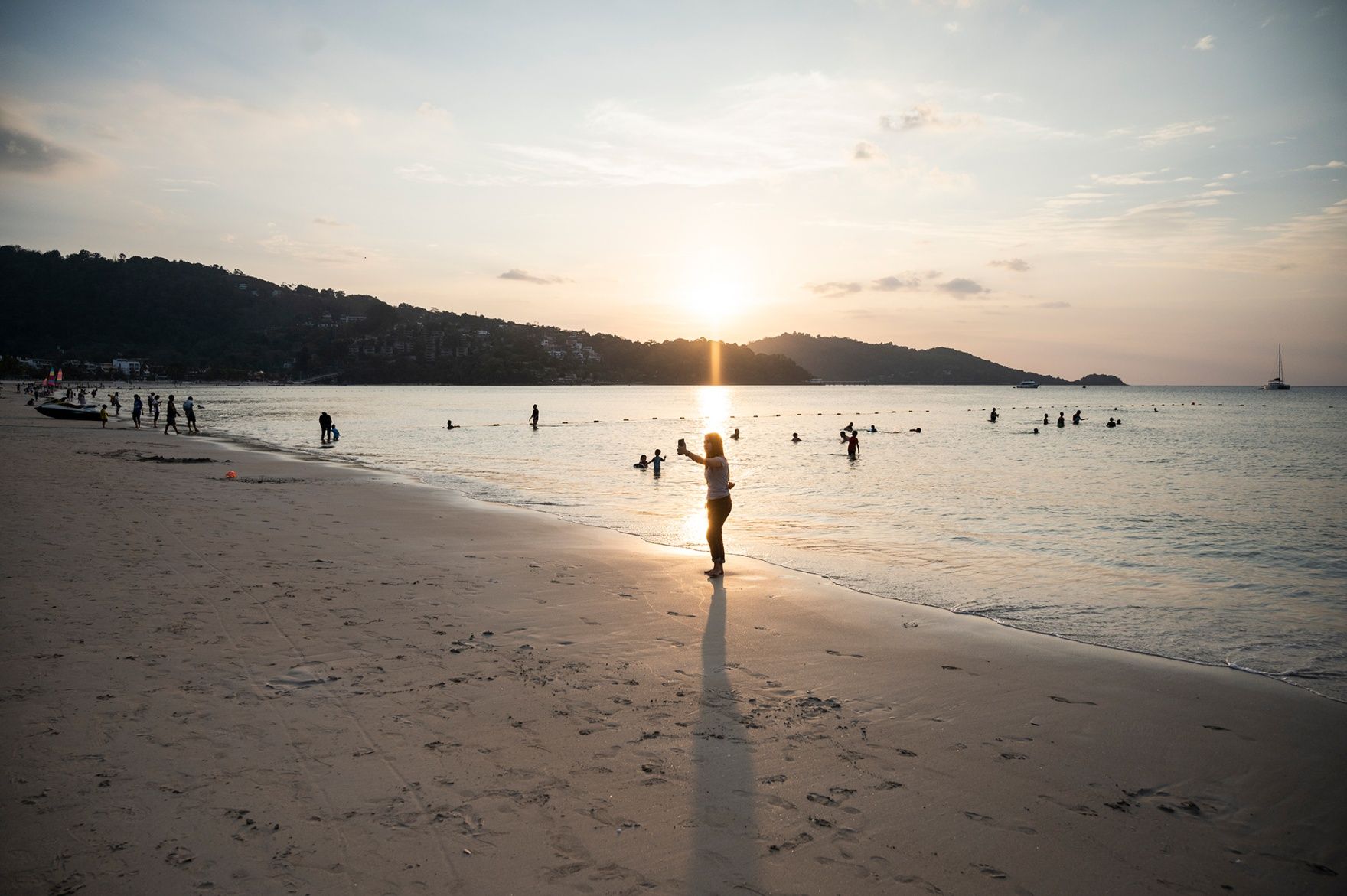 PHUKET, THAILAND - JANUARY 17: A small group of people gather at a relatively empty Patong Beach on January 17, 2021 in Phuket, Thailand. Thailand's tourism-dependent economy was already on life-support before a resurgence of Covid-19 infections, with GDP expected to contract by six per cent in 2020, millions unemployed and record household debt continuing to soar. A fresh lockdown to combat the virus has thrown broad parts of the economy into an extended decline. (Photo by Sirachai Arunrugstichai/Getty Images)