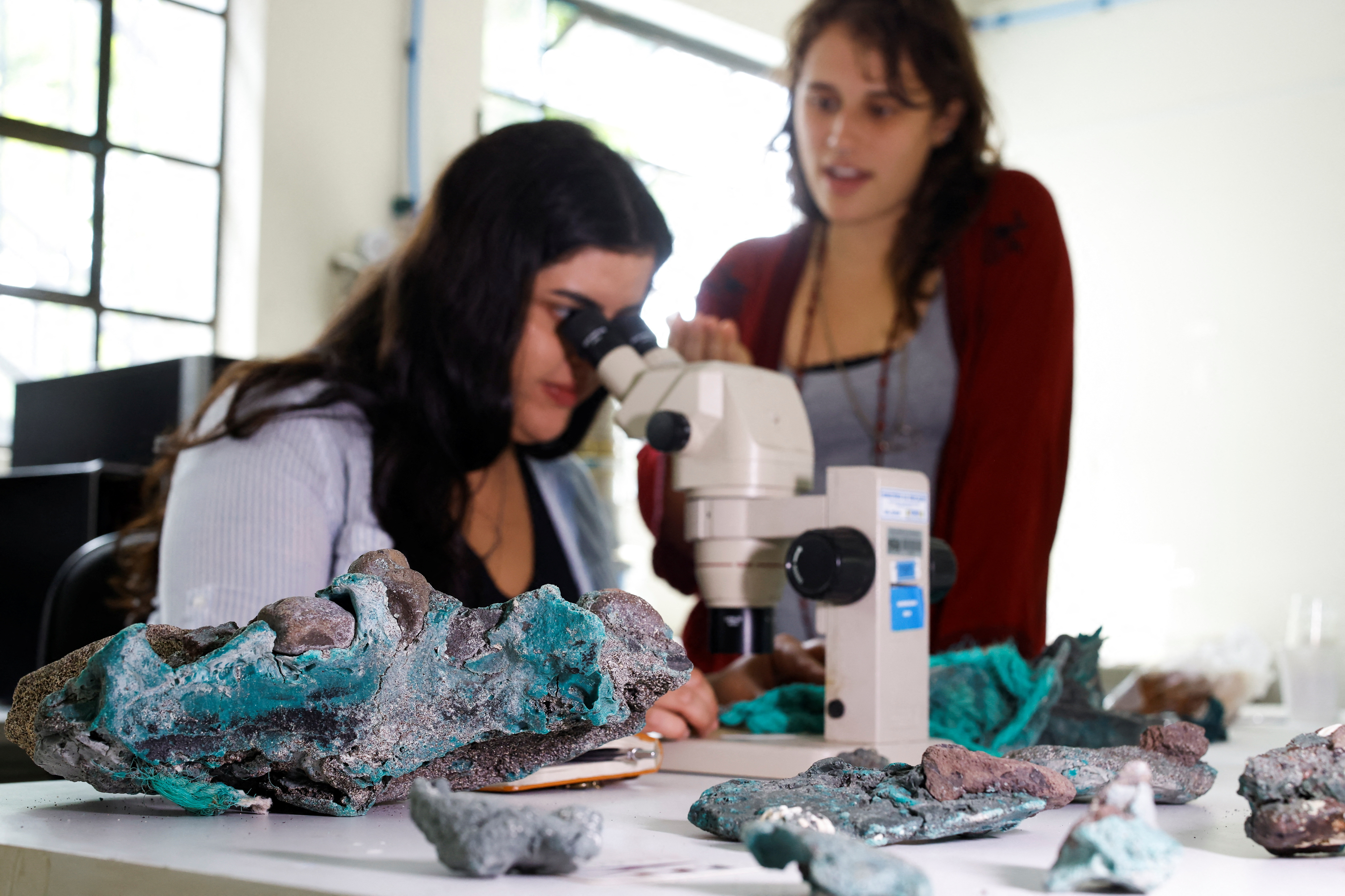 La investigadora Fernanda Avelar Santos mira a través de un microscopio las "rocas plásticas" encontradas en la isla Trindade en el estado de Espirito Santo, en el laboratorio de la Universidad Federal de Paraná, en Curitiba, estado de Paraná, Brasil, 7 de marzo de 2023. REUTERS/Rodolfo Buhrer