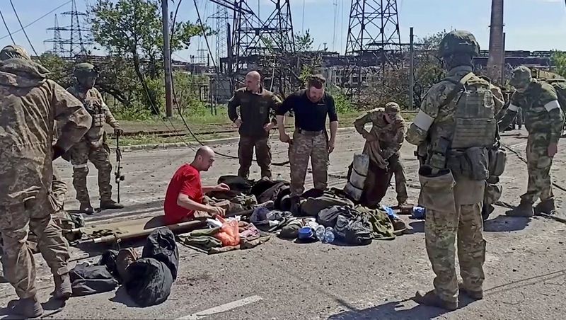 Miembros del servicio de las fuerzas ucranianas que se han rendido tras semanas atrincherados en la acería Azovstal son registrados por los militares prorrusos en Mariúpol, Ucrania, en esta imagen fija tomada de un vídeo publicado el 18 de mayo de 2022. Ministerio de Defensa ruso/Handout via REUTERS