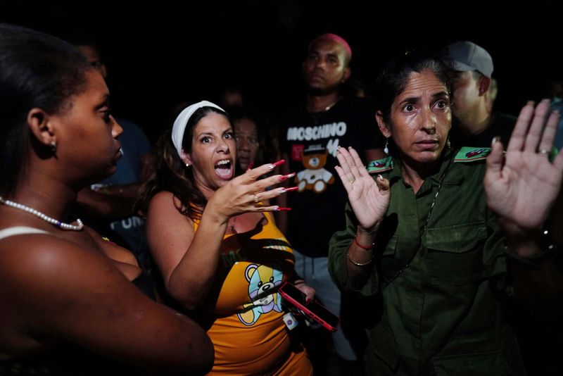 Una oficial del partido comunista local habla con los manifestantes durante las protestas en La Habana, Cuba (REUTERS/Alexandre Meneghini)