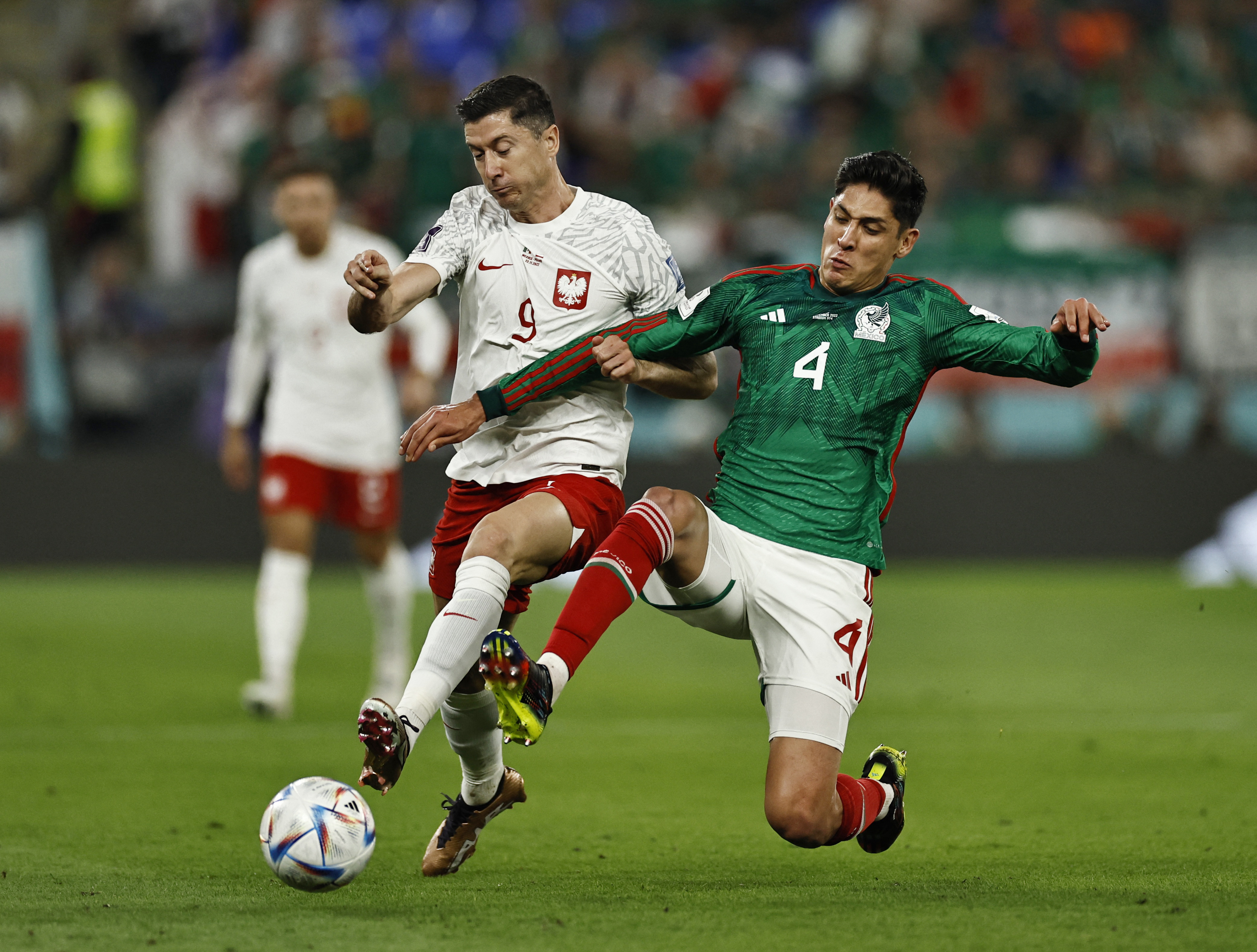 El centrocampista mexicano Edson Álvarez detiene el avance de Robert Lewandowski. REUTERS/Hamad I Mohammed