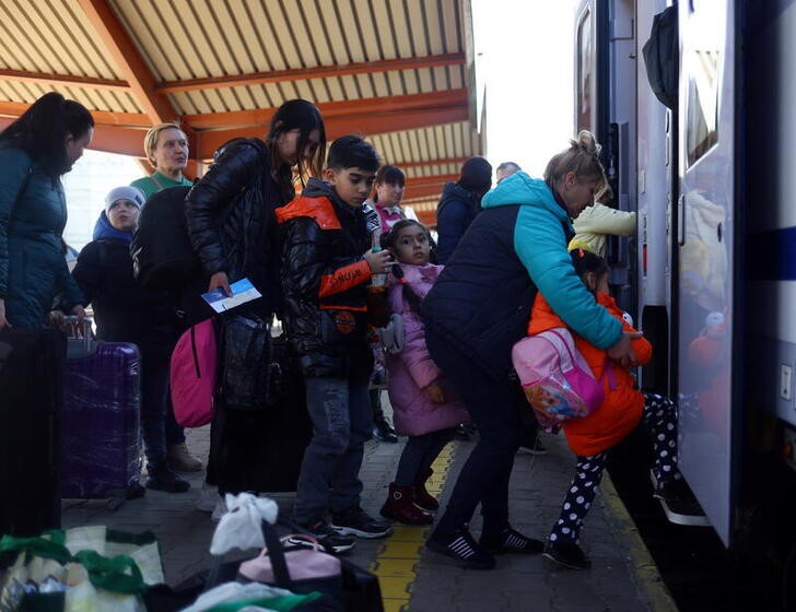 Refugiados ucranianos, entre ellos niños, abordan un tren en la estación de Varsovia, huyendo de la invasión rusa de Ucrania. Polonia, marzo 23, 2022.REUTERS/Hannah McKay