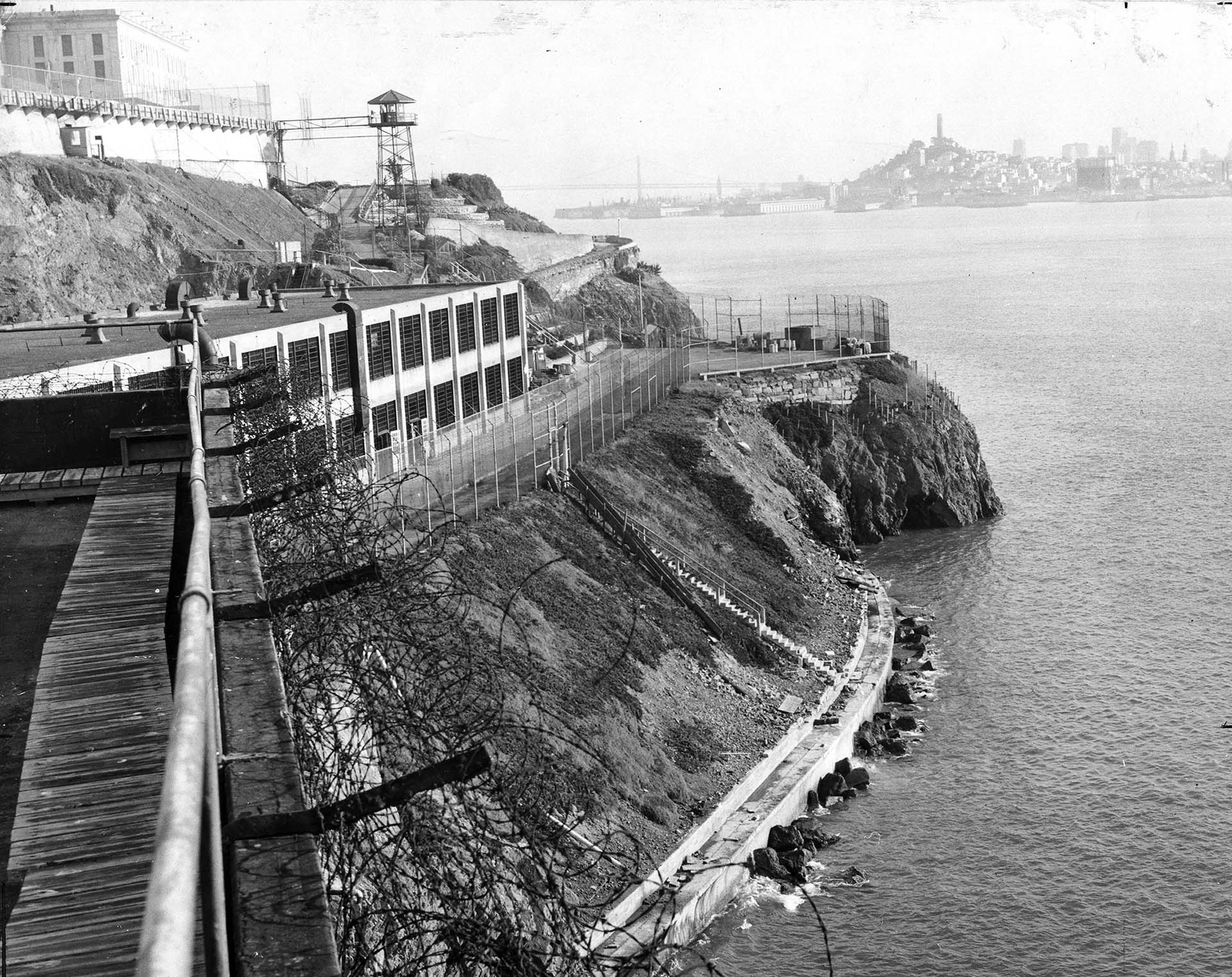 Una vista de la isla de Alcatraz tomada desde el área industrial con una torre de vigilancia, una celda principal y un horizonte al fondo, San Francisco alrededor de 1940 (PhotoQuest/Getty Images)