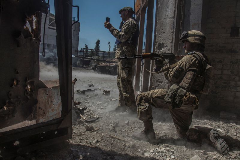 Ukrainische Soldaten beobachten einen Panzerbeschuss auf russische Truppen im Industriegebiet der Stadt Chevrolet Donezk