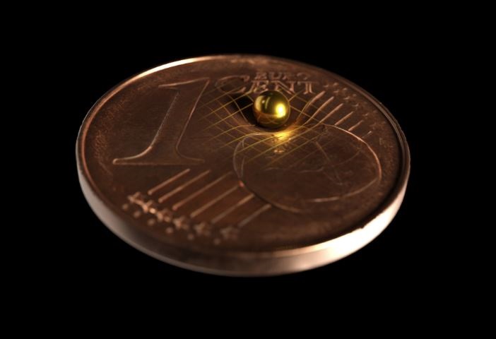 La bola de oro utilizada en comparación de tamaño con una moneda de 1 centavo. Según la teoría de la relatividad general de Einstein, toda masa dobla el espacio-tiempo (TOBIAS WESTPHAL / ARKITEK SCIENTIFIC)
