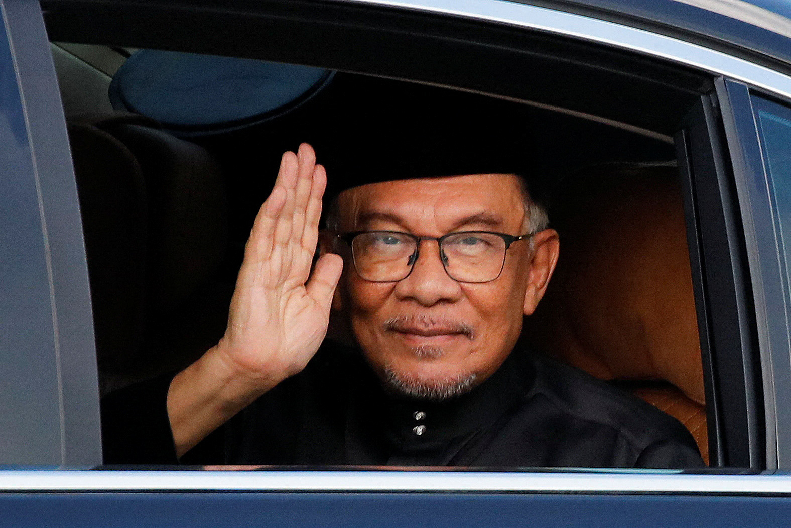 Malaysia's new Prime Minister Anwar Ibrahim greets the photographer as he arrives at the National Palace in Kuala Lumpur, Malaysia November 24, 2022. Fazry Ismail/Pool via REUTERS