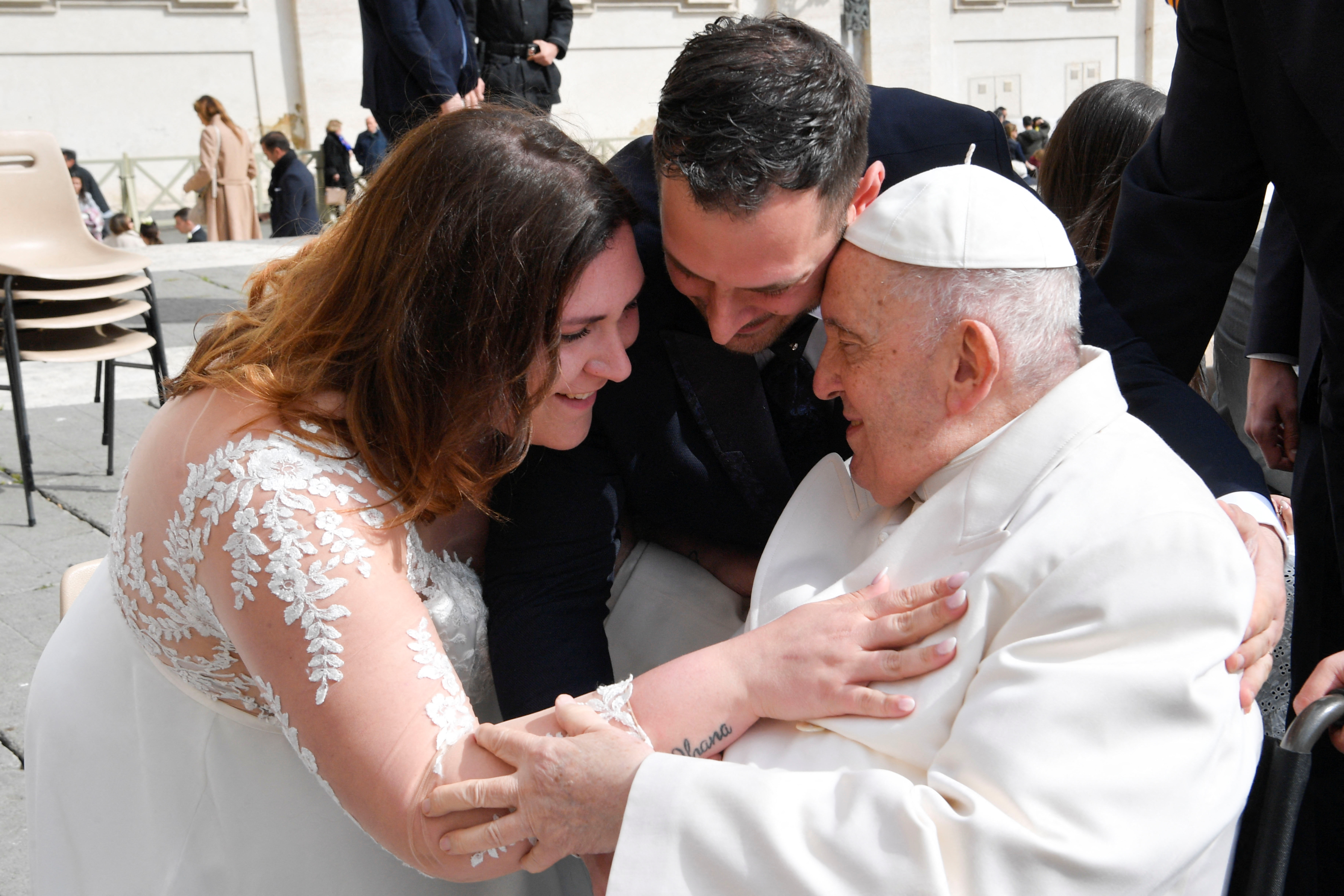 El papa abraza una pareja durante la audiencia general del miércoles (Prensa del Vaticano/REUTERS)