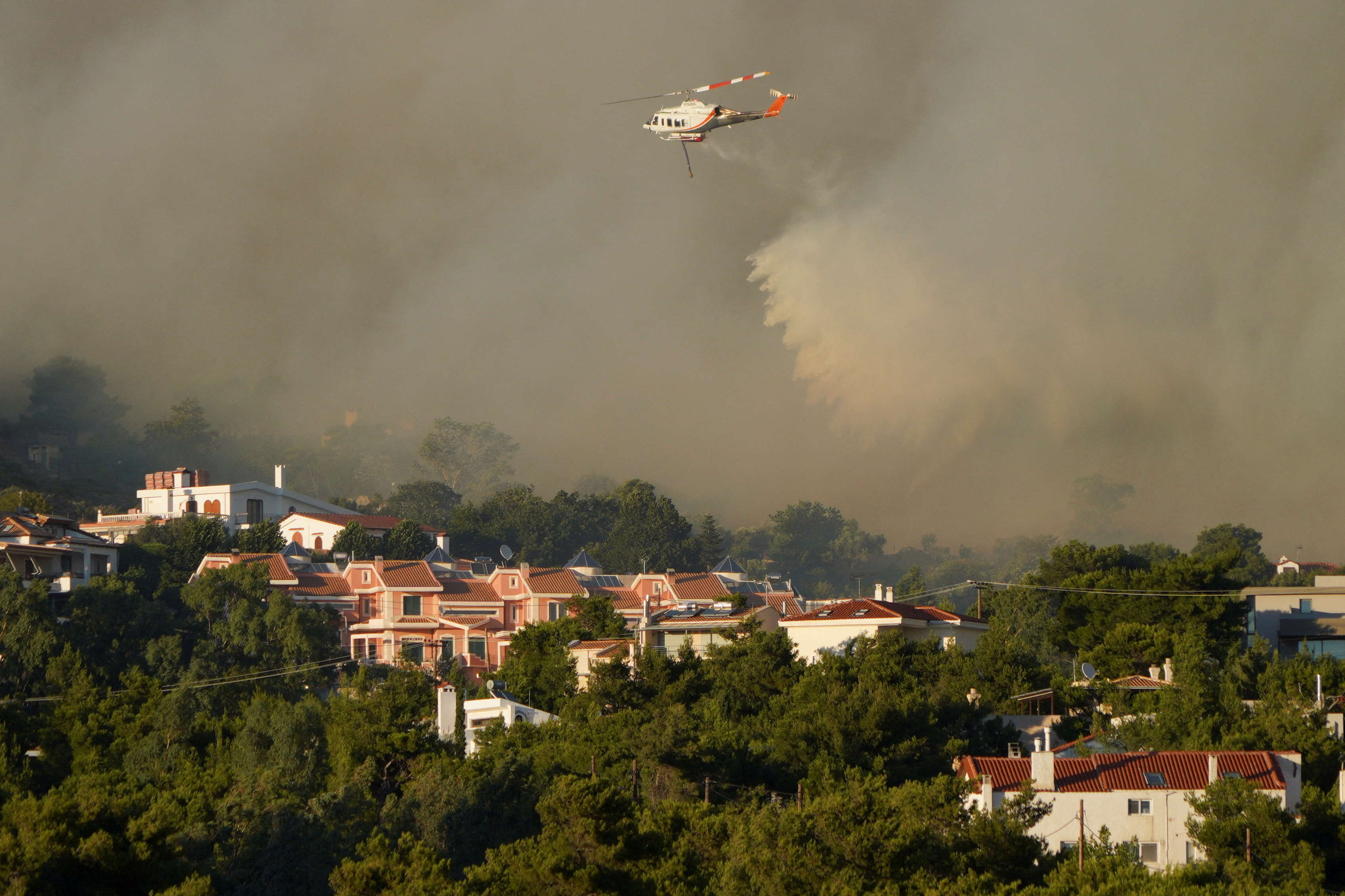 Un helicóptero de extinción de incendios lanza agua  (REUTERS/Vassilis Triandafyllou)