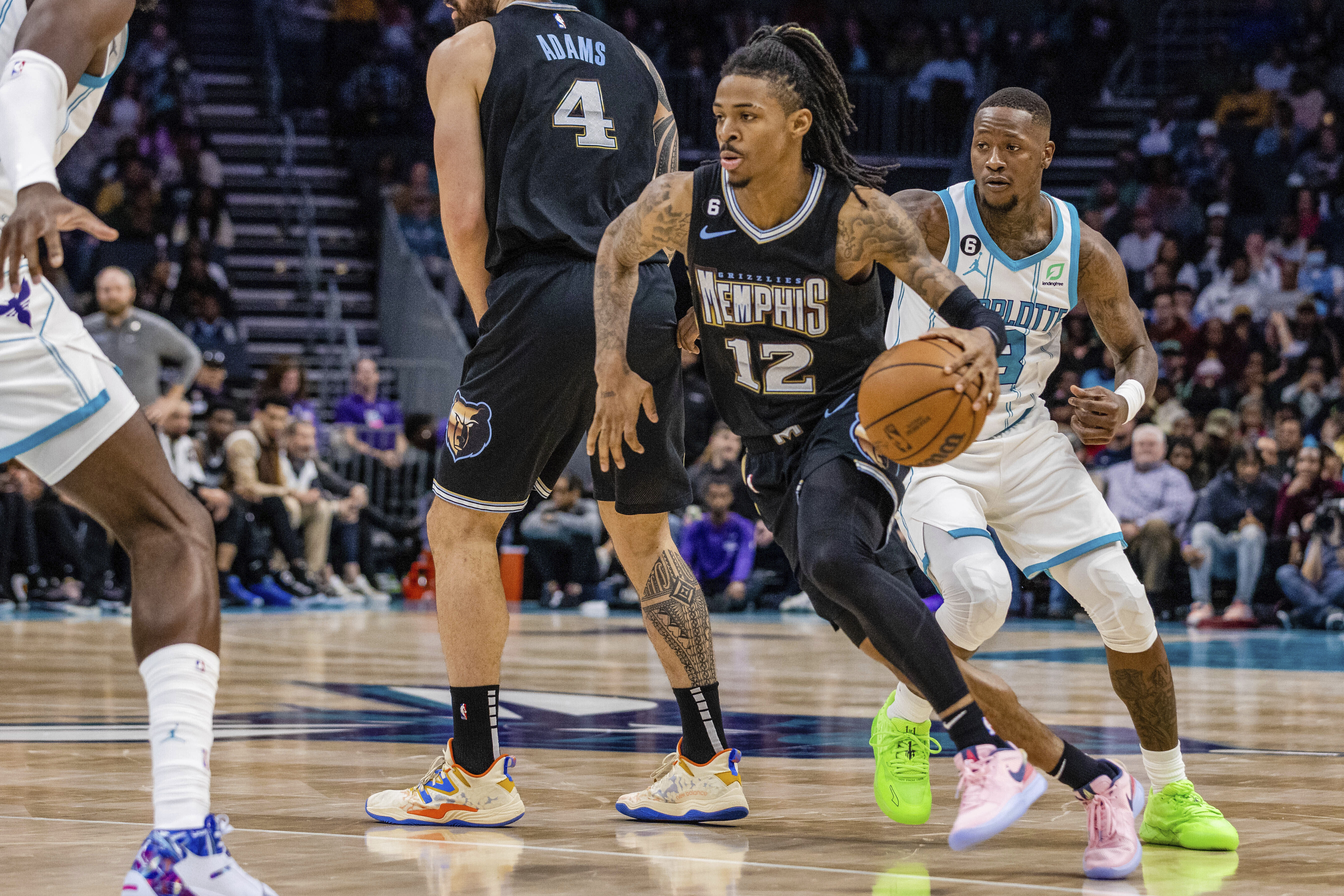Memphis Grizzlies guard Ja Morant uses a screen from center Steve Adams to get past Charlotte Hornets guard Terry Rozier in a game on Wednesday, Jan. 4, 2023. (AP Photo/Scott Kinser)