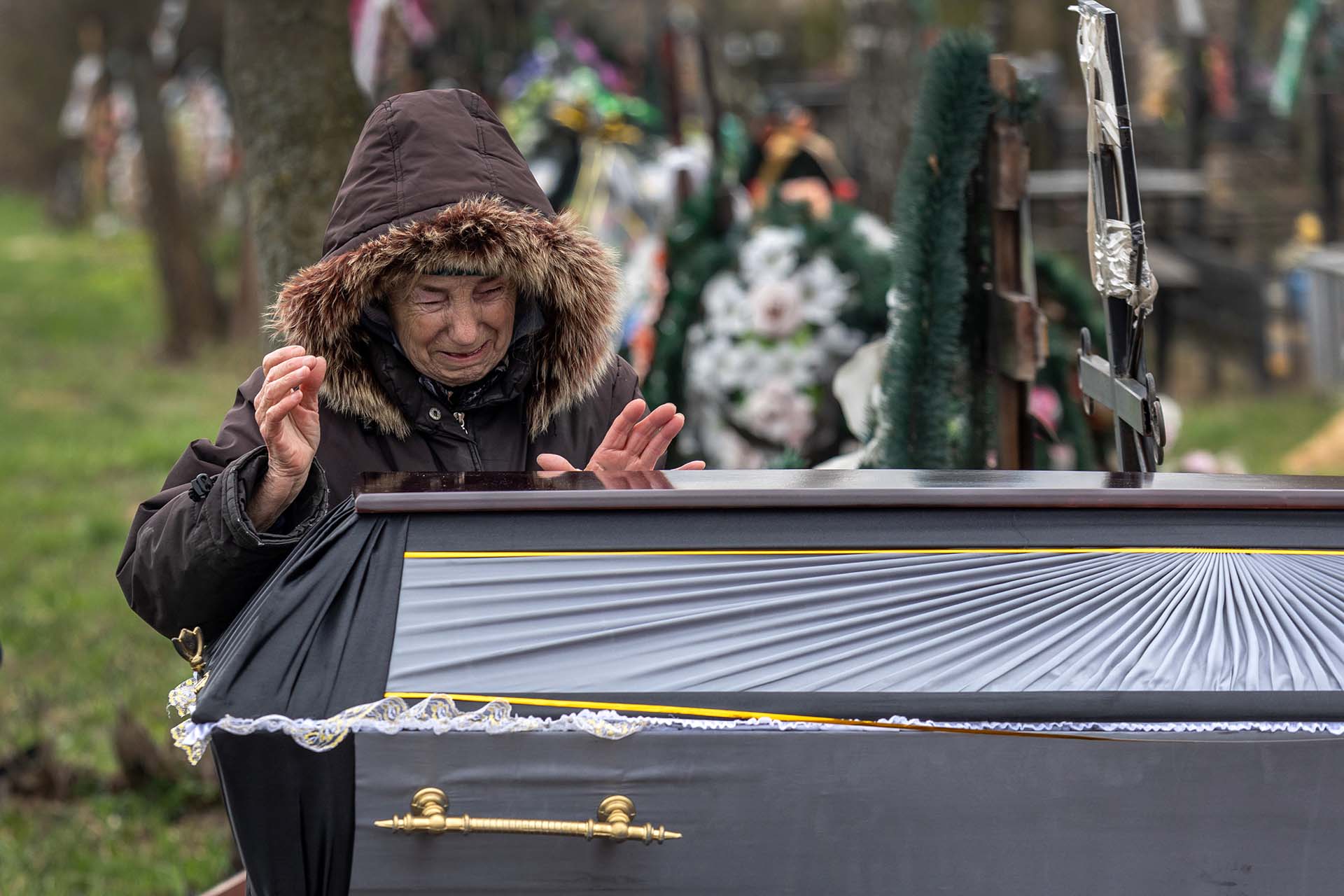 Alentyna Nechyporenko, de 77 años, llora sobre la tumba de su hijo  Ruslan, de 47, durante su funeral en Bucha