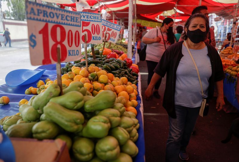 Compradores pasan junto a puestos de verduras en un mercado de Ciudad de México. REUTERS/Luis Cortés