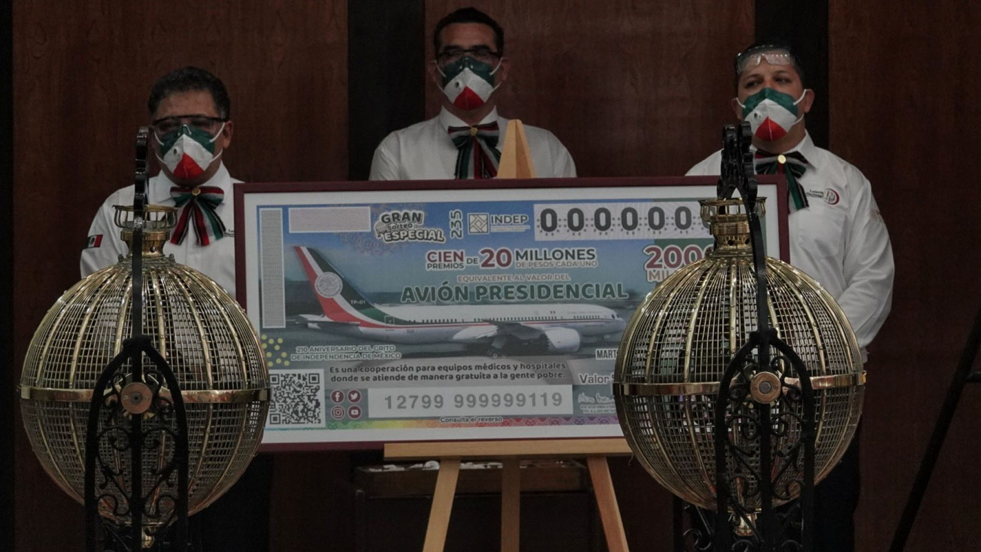Trabajadores de la lotería junto a una replica gigante del boleto para la rifa del avión presidencial (Foto: Cuartoscuro)