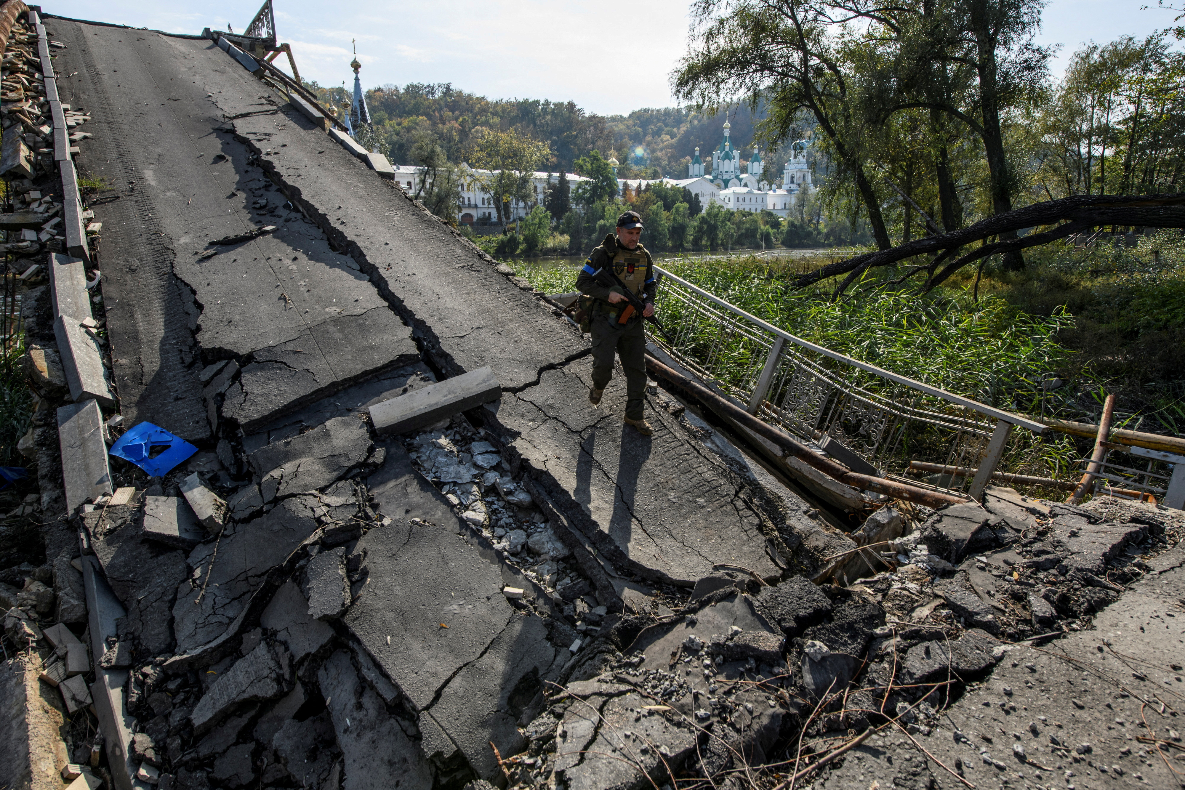 A Member Of The National Guard Service Of Ukraine Walks Across A Bridge Over The Siversky Donets River, Destroyed During Russia'S Invasion Of Ukraine, In The City Of Sviatohirsk, Donetsk Region, Ukraine October 1, 2022.  Reuters/Vladislav Musienko