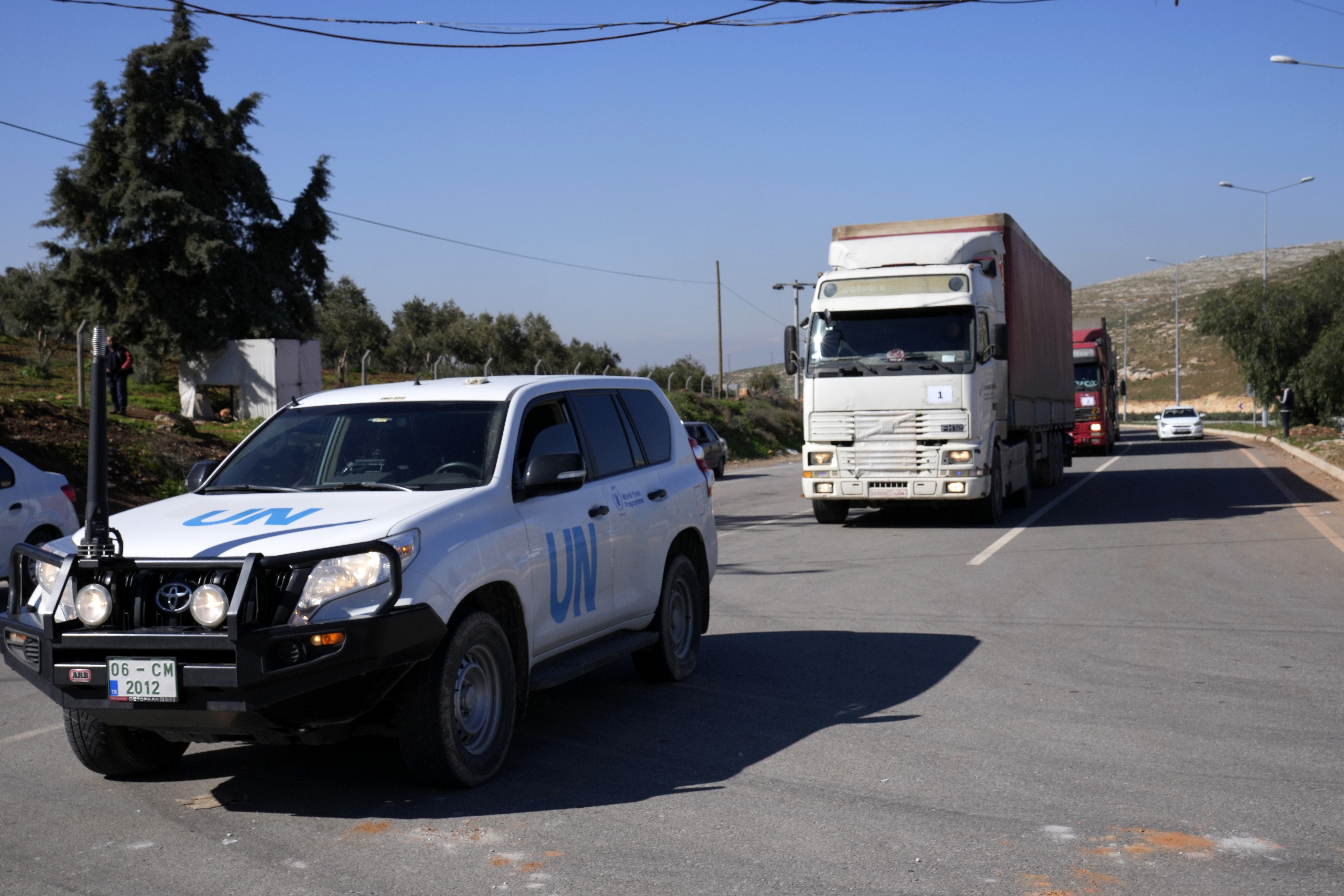Camiones con ayuda para Siria tras el terremoto del 6 de enero siguen a un vehículo de la ONU en el punto de cruce turco de Cilvegozu, en Reyhanli, sureste de Turquía, el jueves 9 de febrero de 2023. (Foto AP/Hussein Malla)