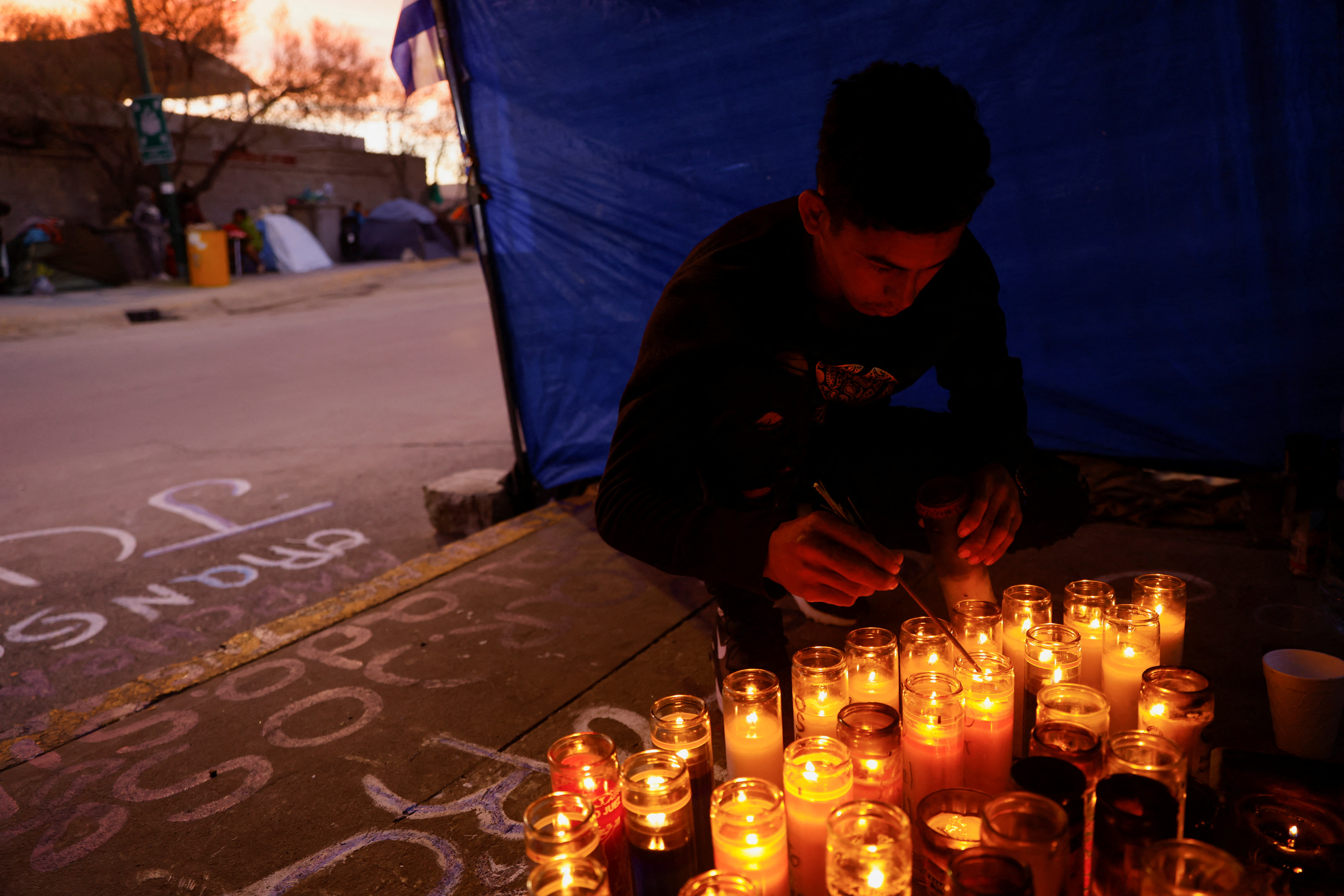 Migrante prende veladoras para sus compañeros muertos en el incendio en Ciudad Juárez (REUTERS/Jose Luis Gonzalez)