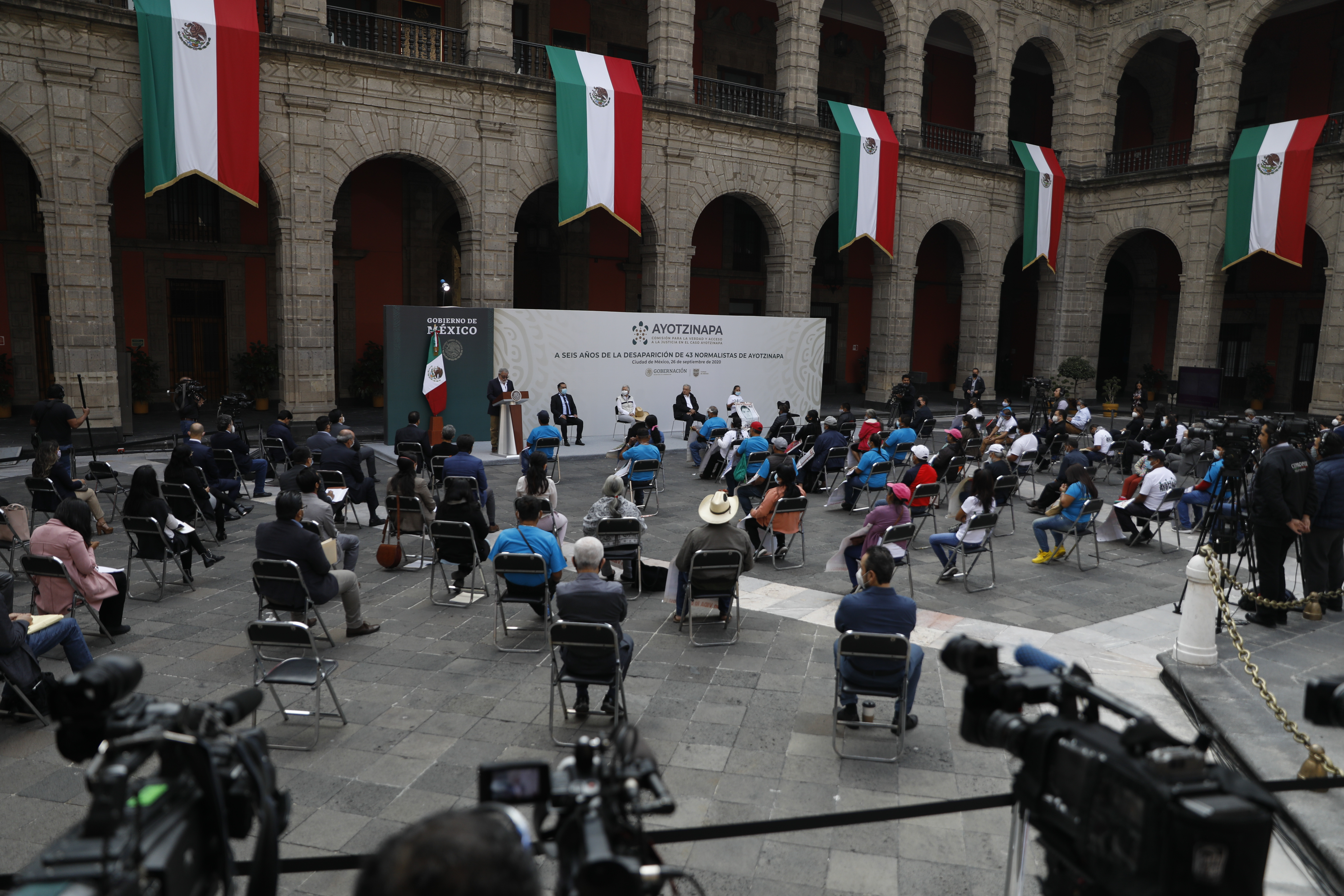 Mexico's President Andres Manuel Lopez Obrador, left, and Deputy Interior Secretary Alejandro Encinas, right, applaud for Maria Martinez, mother of Miguel Angel Hernandez Martinez, as she is introduced as a representative of the family members of 43 missing students from the Rural Normal School of Ayotzinapa, during an event to update the ongoing investigations on the sixth anniversary of the students’ disappearance, at the National Palace in Mexico City, Saturday, Sept. 26, 2020. (AP Photo/Rebecca Blackwell)