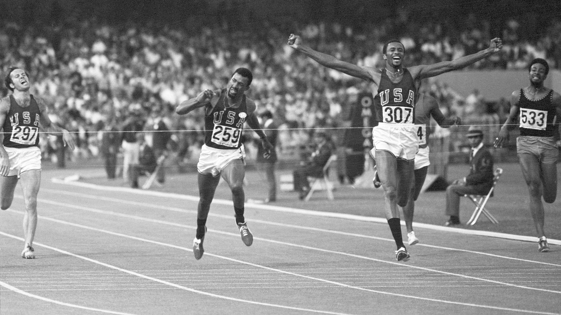 (Original Caption) 10/17/1968-Mexico City: Tommie Smith of Lemore, Calif., throws his arms up in victory as he hits the tape to win a gold medal in the men's 200-meter dash Oct. 16th with a time of 19.8 seconds--a new world record. Running despite an injured leg muscle, he steaked past teammate John Carlos of San Jose, Calif. (left), who placed third behind Peter Norman (behind Smith) of Australia.