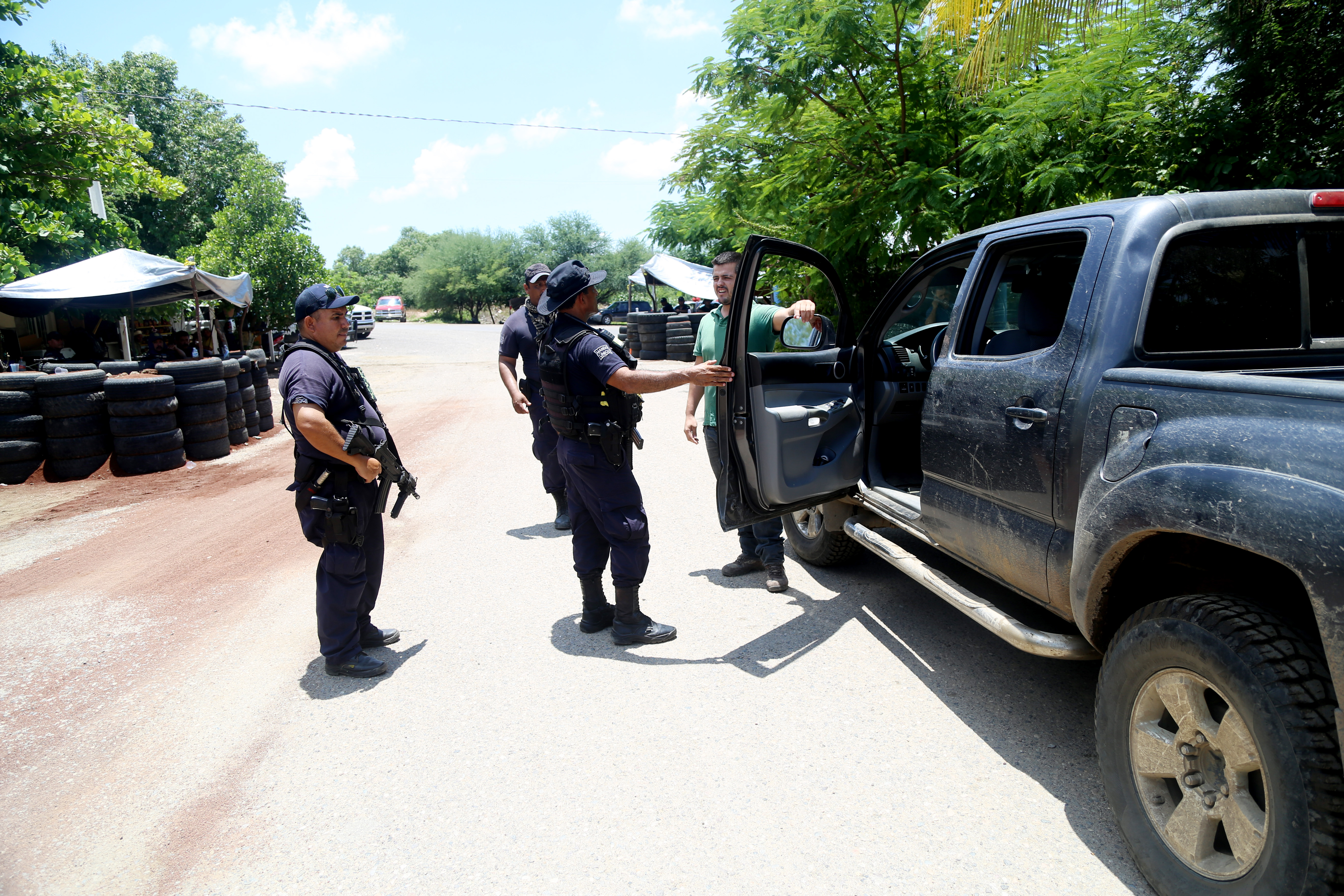 Elementos de la Policía Michoacán y Municipal revisan sobre la carretera Tepalcatepec-Jilotlán de los Dolores a la altura del crucero Cholula. (Foto: JUAN JOSÉ ESTRADA SERAFÍN /CUARTOSCURO)